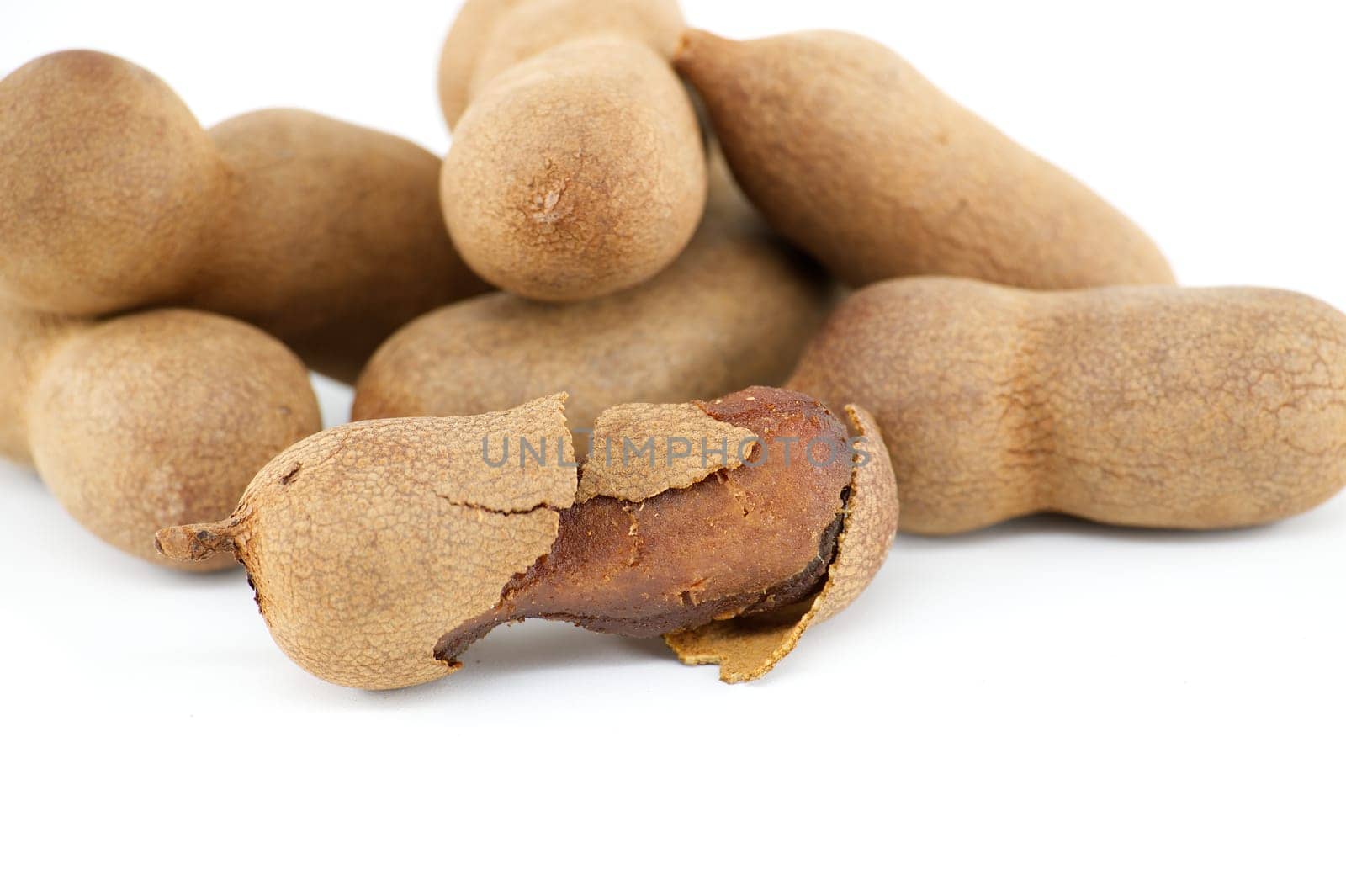 Tamarind whole and cracked open on white background by NetPix