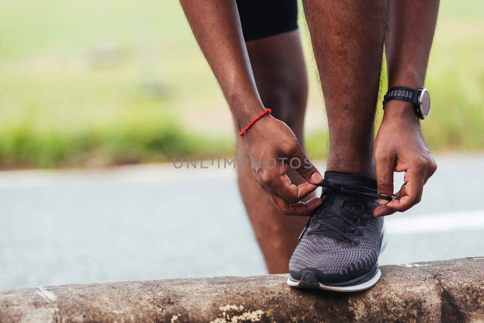 Close up Asian sport runner black man wear watch stand step on the footpath trying shoelace running shoes getting ready for jogging and run outdoor street health park, healthy exercise workout concept