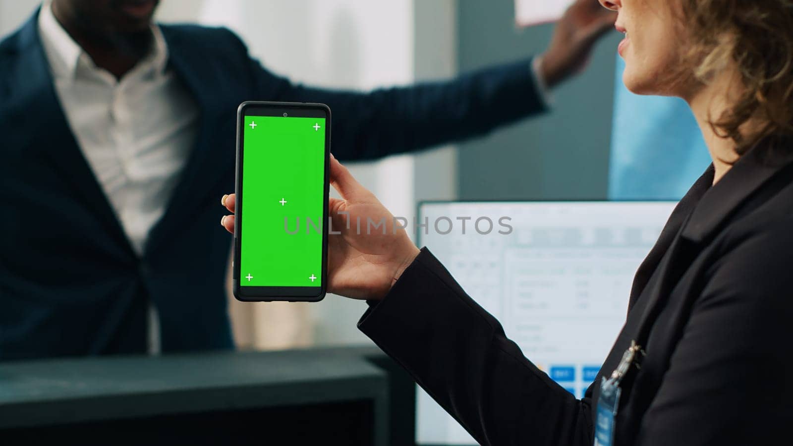 Mall employee showing greenscreen layout on phone at checkout counter, working in fashion industry and selling clothing. Assistant looking at mobile device display with mockup template. Camera A.