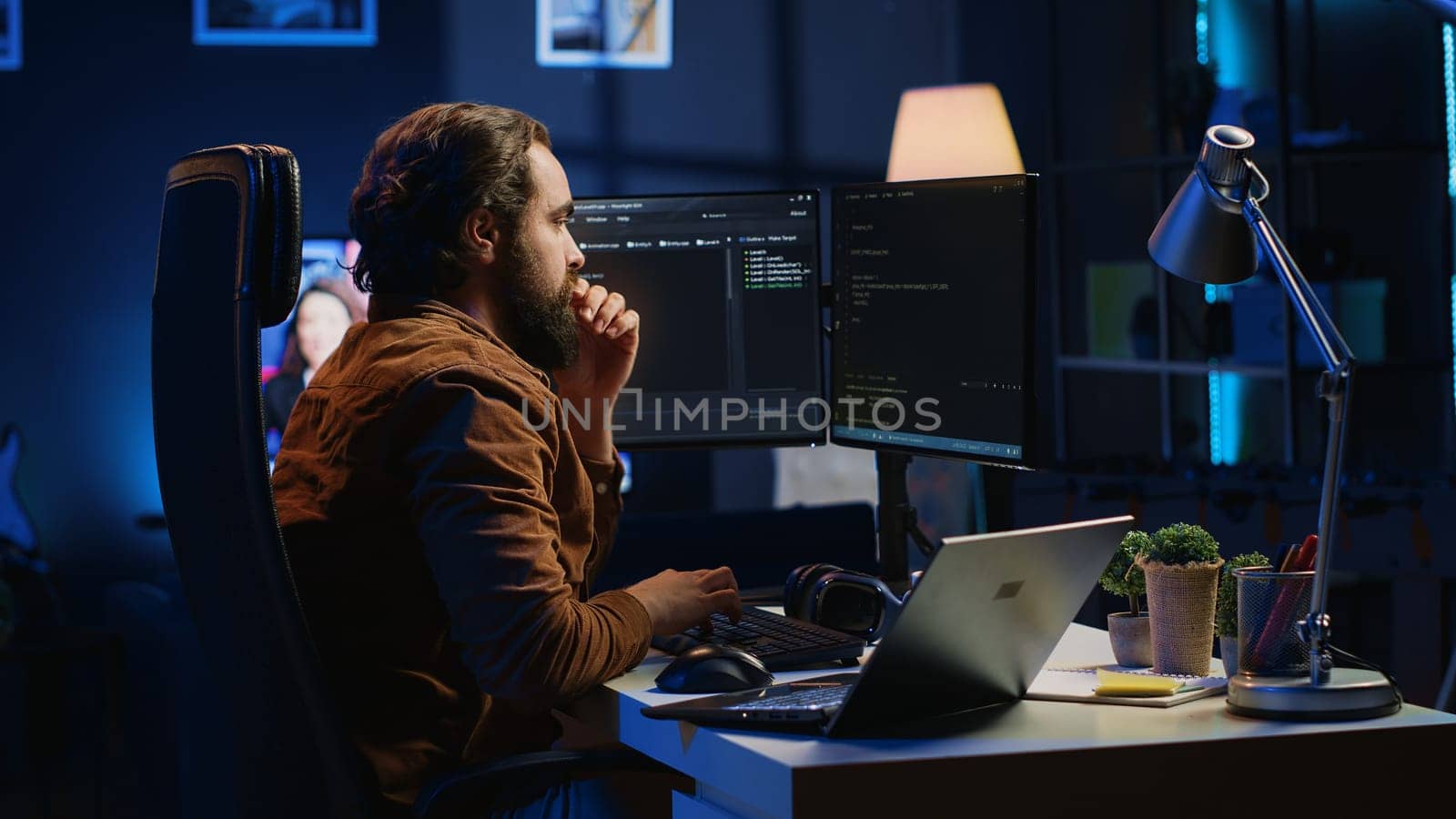Developer typing code in home office, using Java programming language to develop software application. It professional using multimonitor PC setup and laptop to finish tasks, camera A