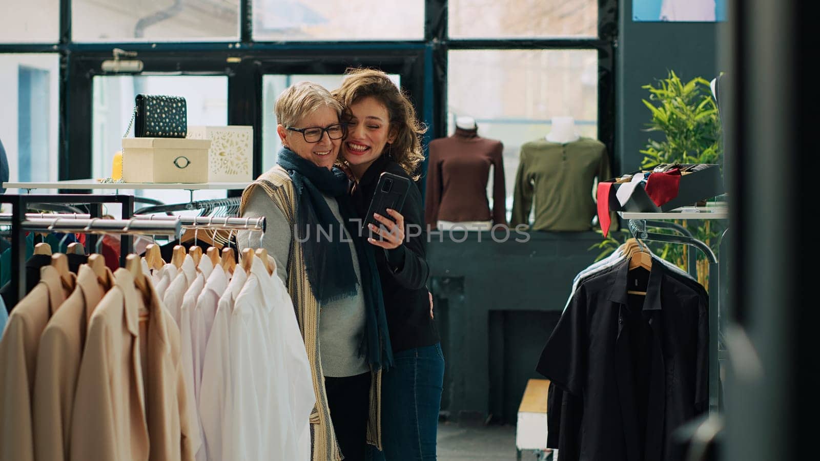 Senior woman and her daughter take photos in department store by DCStudio