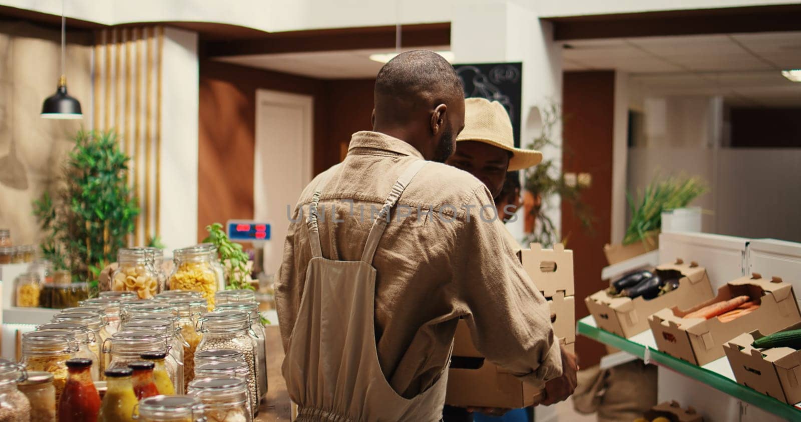 Small business owner receiving new produce stock from contractor, bringing freshly harvested natural products from local farm. African american man supplying organic grocery store. Camera 2.