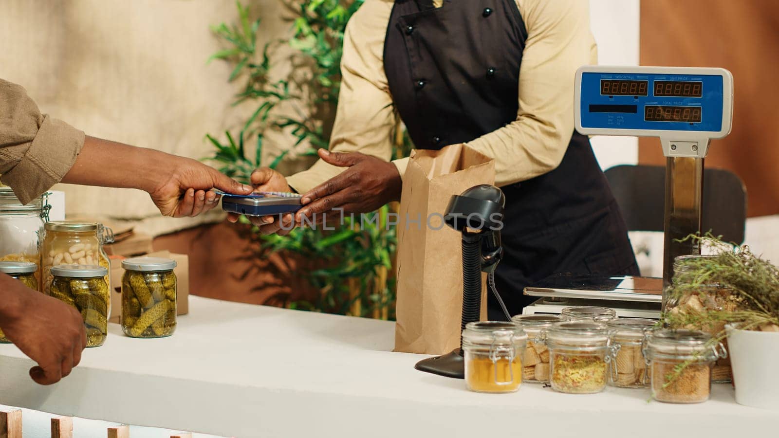 Vegan customer using card at pos to pay for natural food alternatives by DCStudio