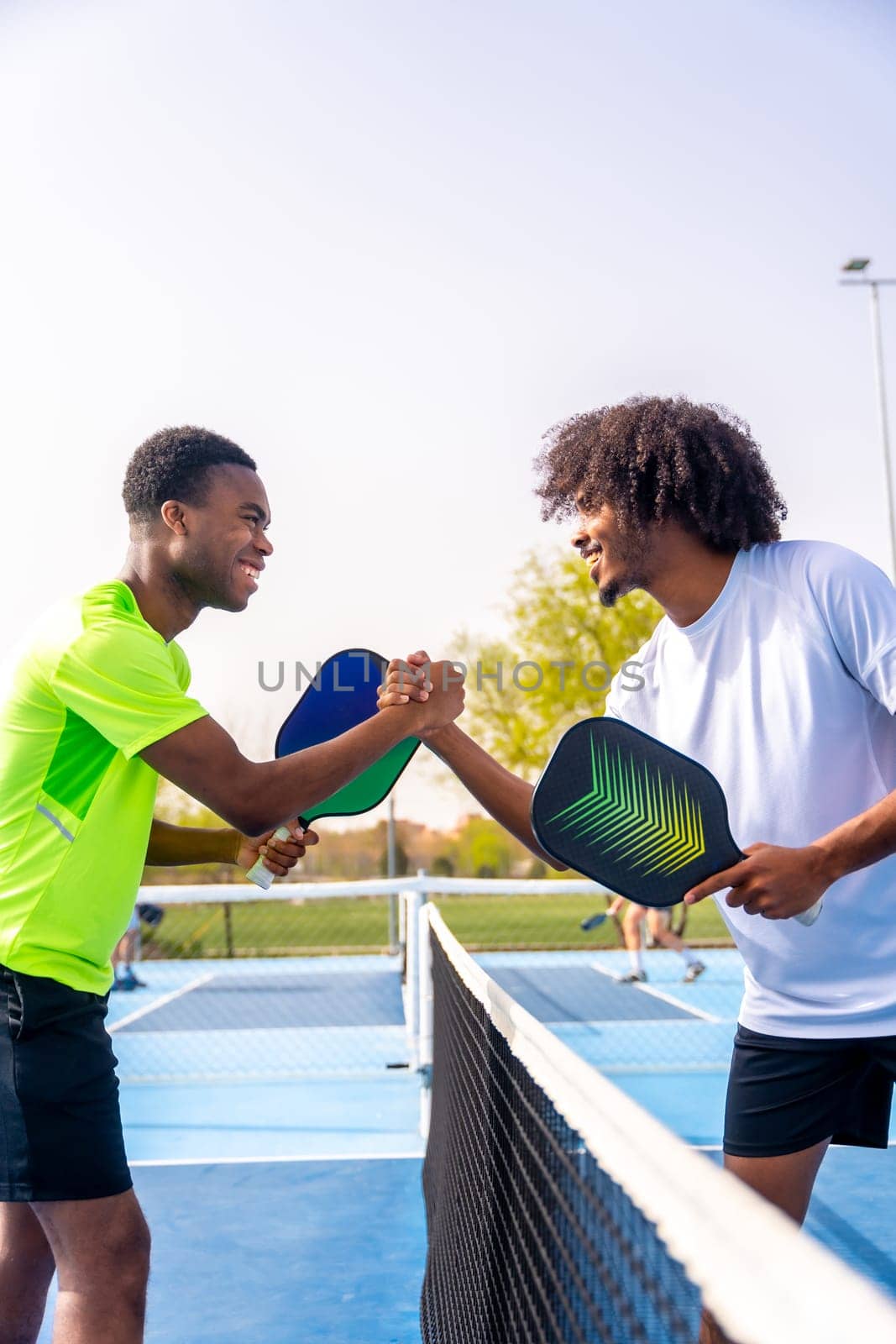African sportive men shaking hands before playing pickleball by Huizi