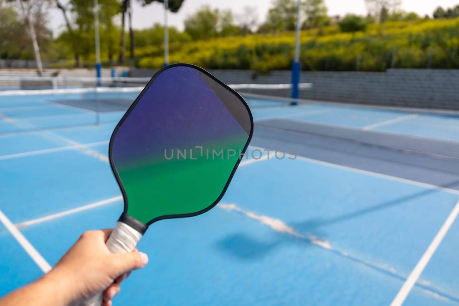 Close-up of a hand holding pickleball racket by Huizi