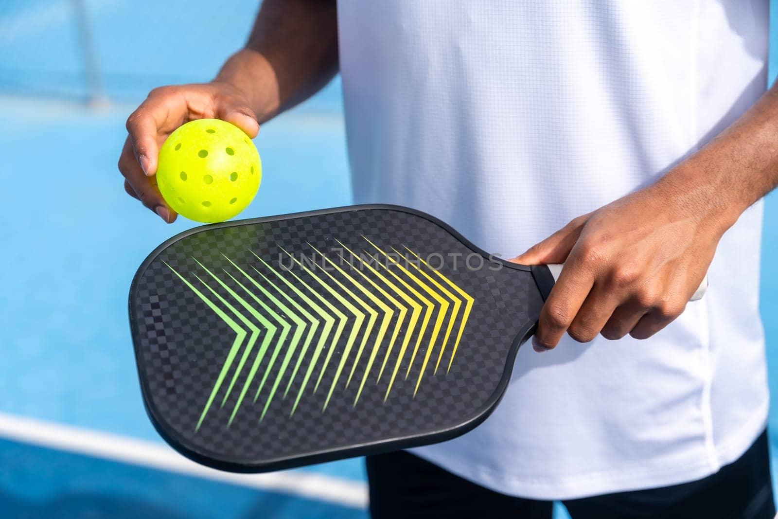 Unrecognizable close-up sportive man with pickleball equipment by Huizi