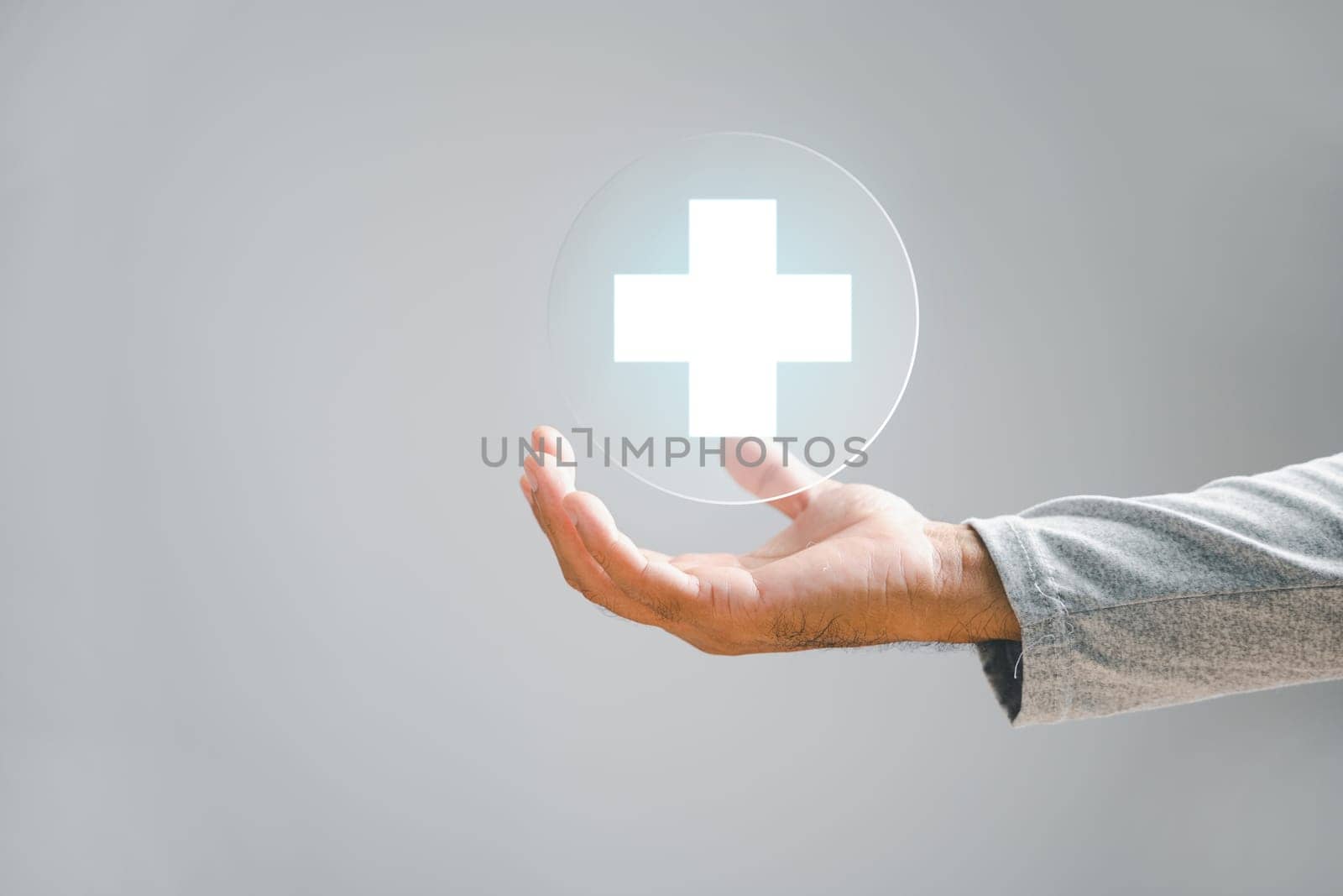 Businessman hand holds a plus sign, signifying positivity, benefits, personal development, social network. Portrays value addition and incentives in a corporate scene.