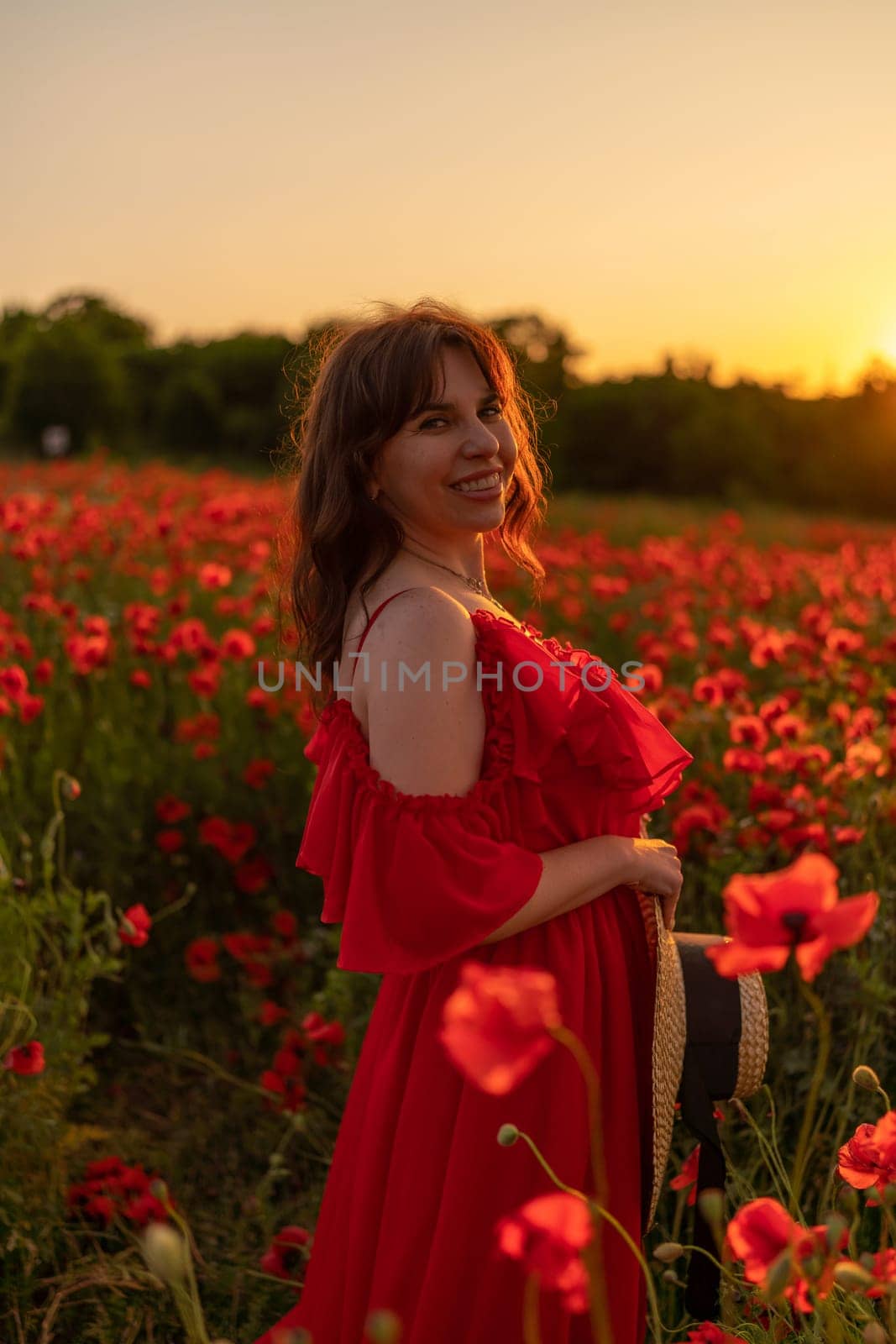 Woman poppy field red dress sunset. Happy woman in a long red dress in a beautiful large poppy field. Blond stands with her back posing on a large field of red poppies by Matiunina