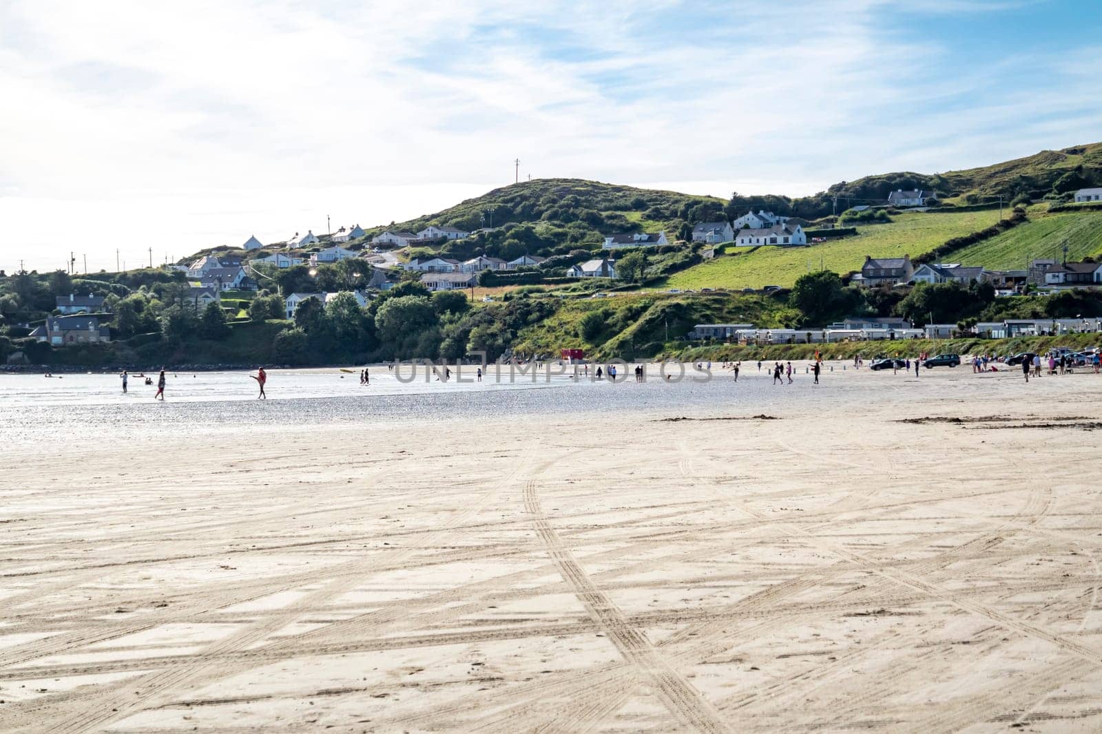 DOWNINGS, IRELAND - JULY 31 2022: Holiday makers enjoying the beach.