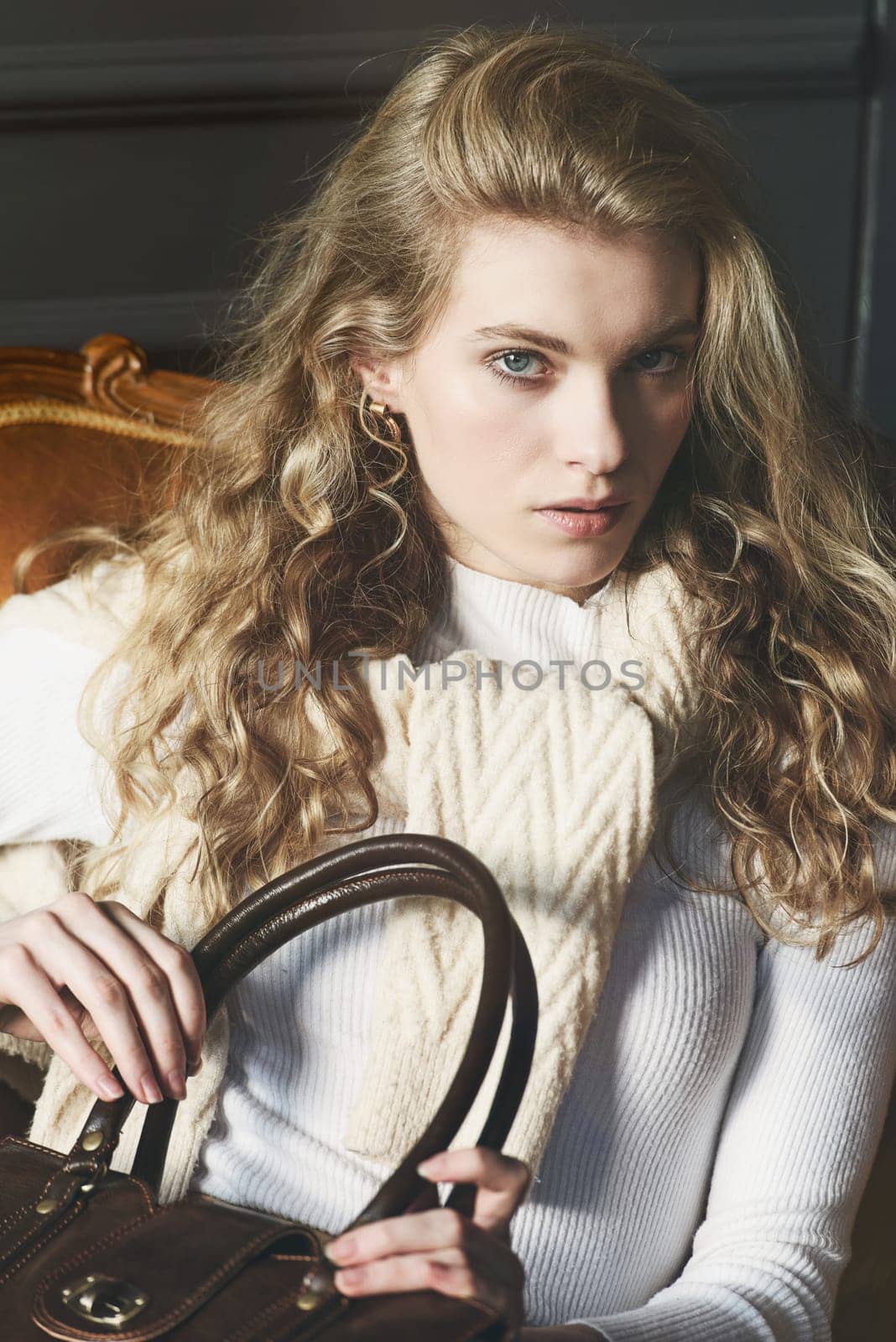 beautiful curly blond hair woman posing with a small shopper brown bag in a vintage chair by Ashtray25