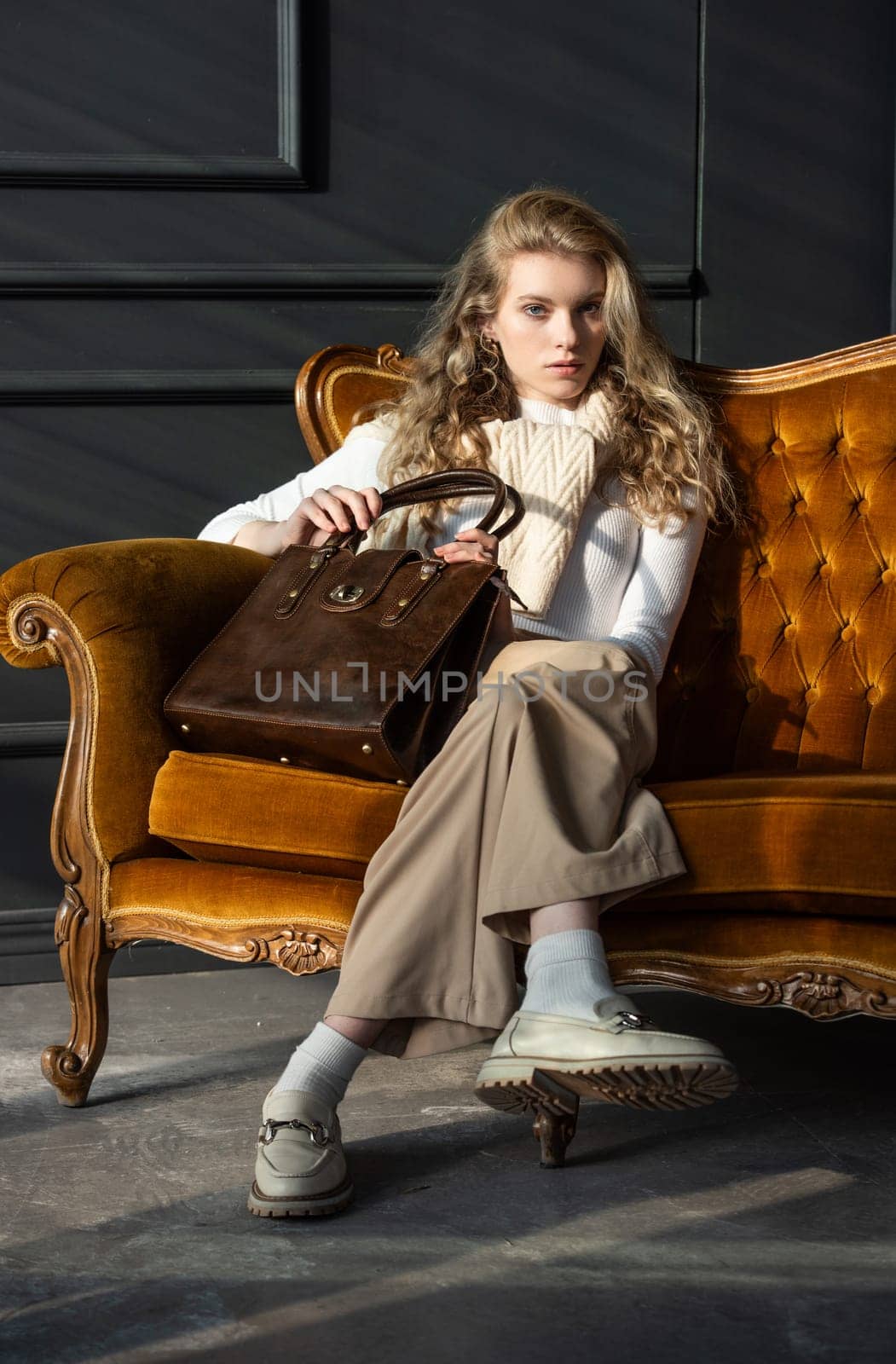 beautiful curly blond hair woman posing with a small shopper brown bag in a vintage chair by Ashtray25
