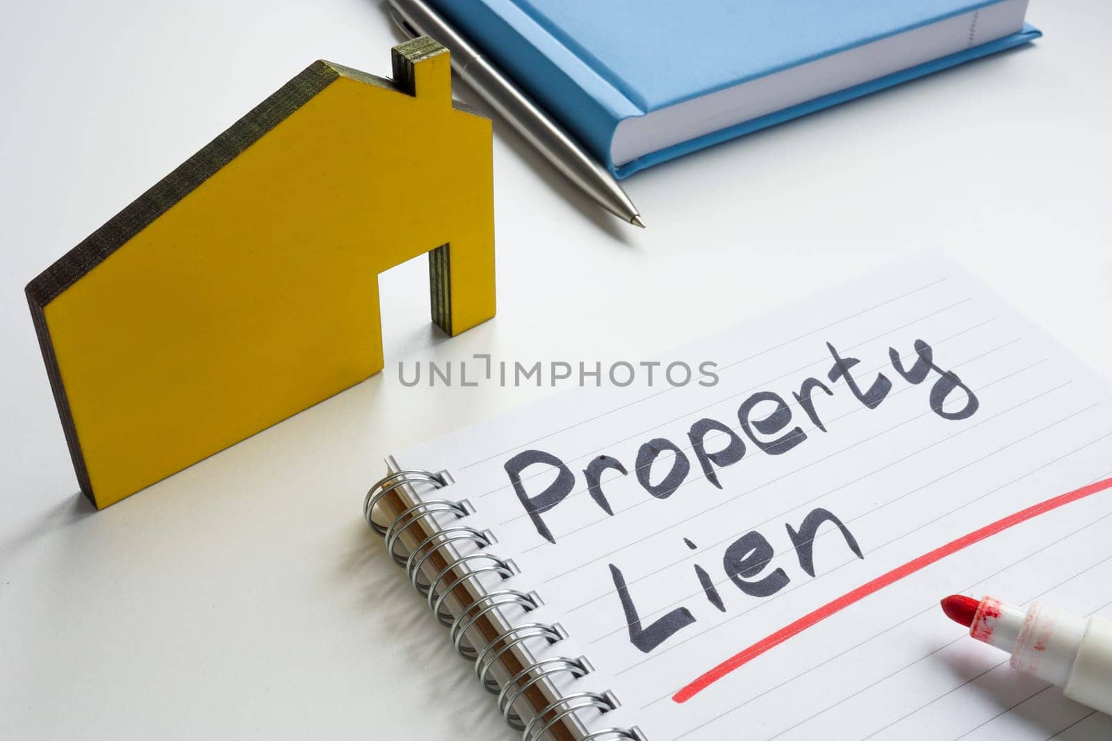 Property lien. Small house and writing in a notebook. by designer491