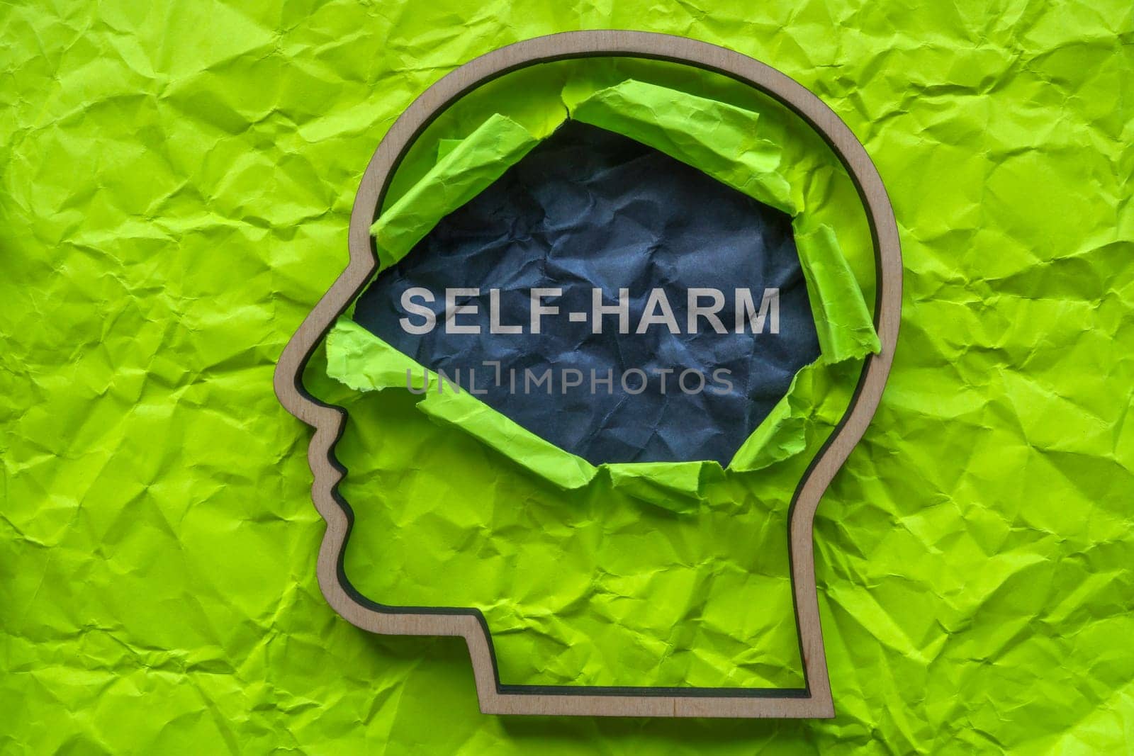 Self-harm concept. Outline of a head and torn paper. by designer491