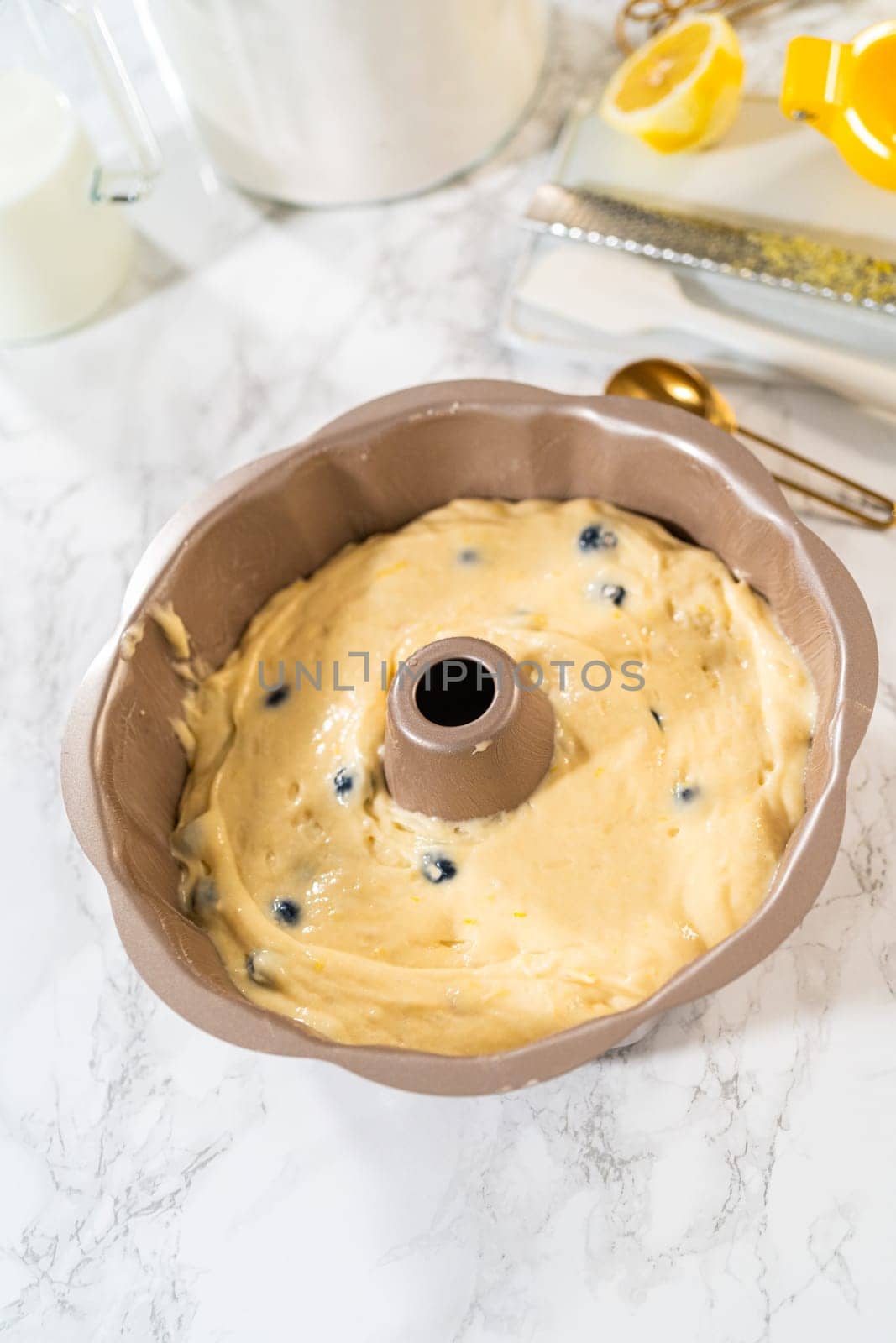 Delicately transferring the cake batter into the pre-greased bundt cake pan, setting the stage for a successful baking process.