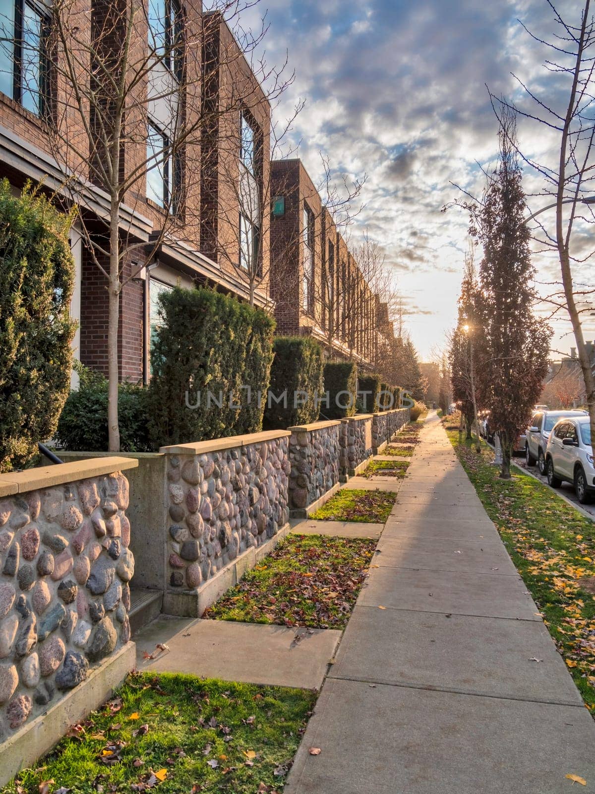 Sidewalk along townhouses on autumn season in Queensborough residential community.