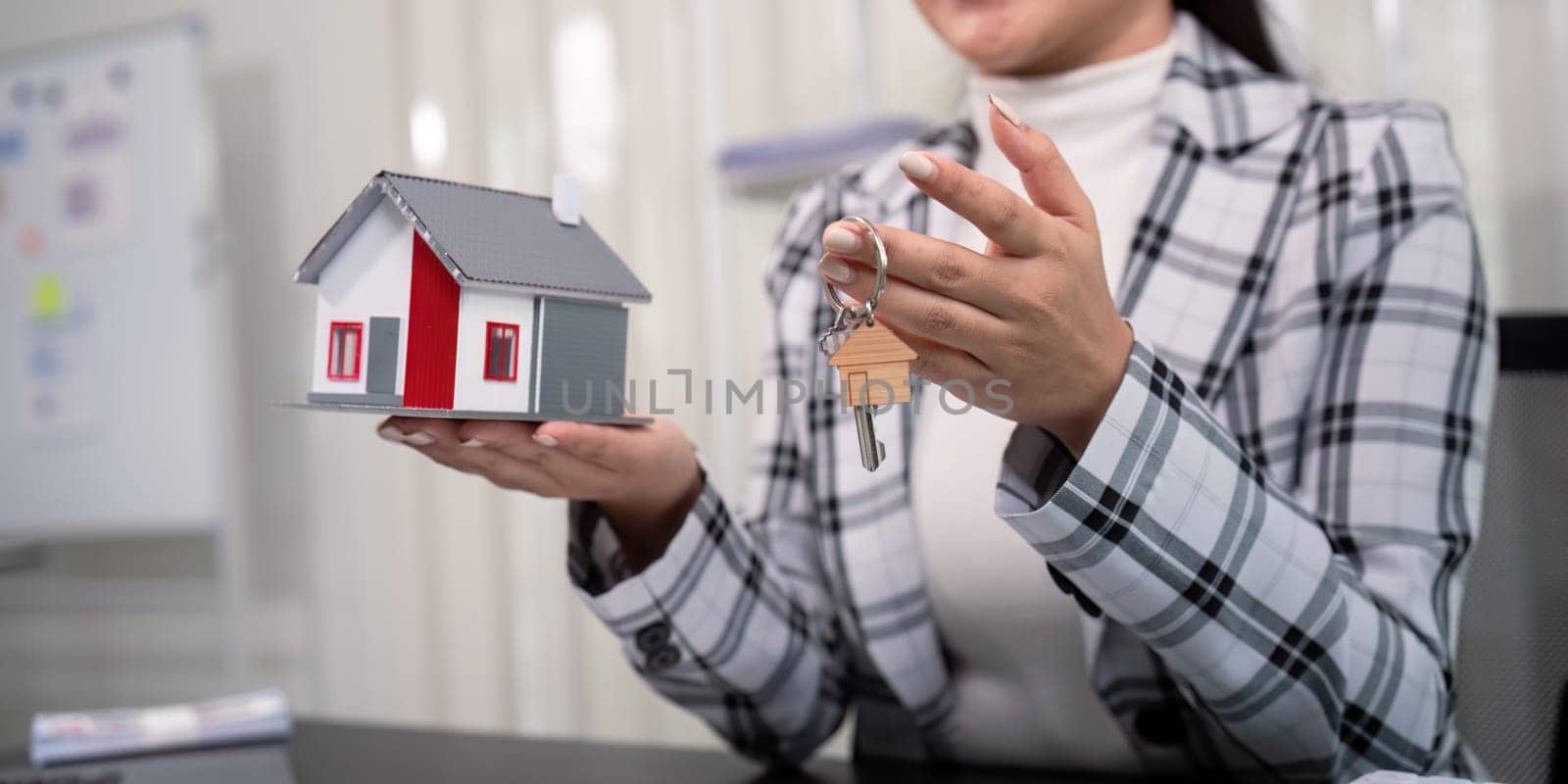 Real estate agent with house model and key.