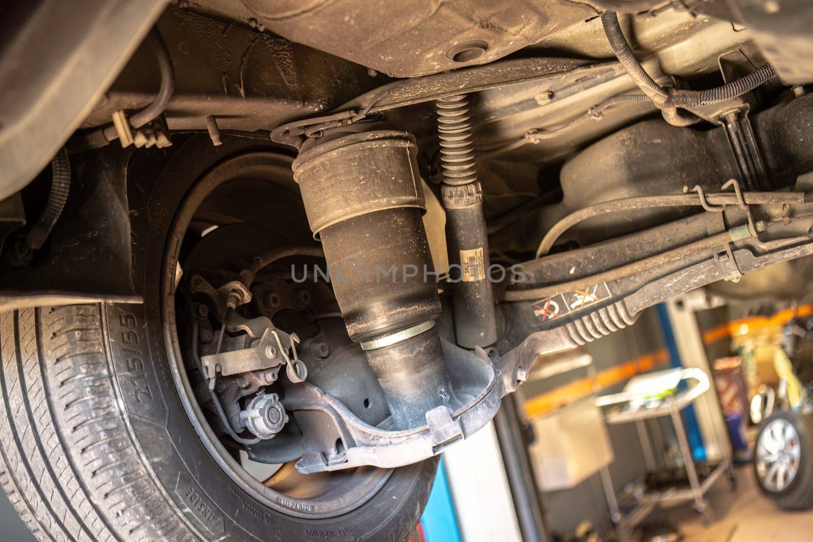 Detailed view of air suspension repair with bellows in car workshop, showcasing expertise.