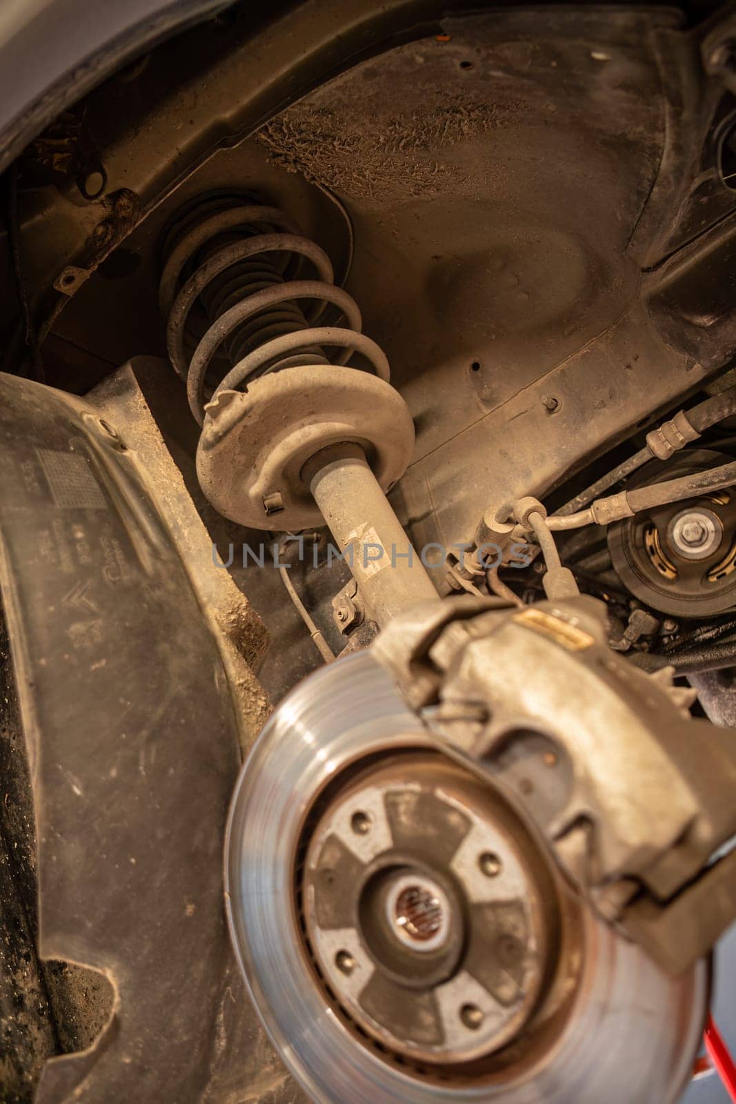 Close-up of a disassembled car suspension shock in workshop, showcasing repair skills.
