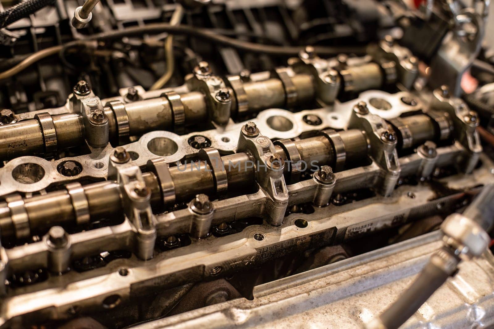 Close-up of a car's disassembled engine showing camshaft detail during workshop repair.