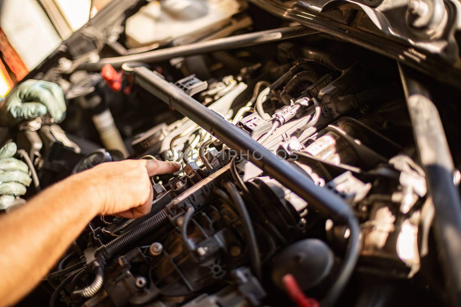 Close-up of a mechanic's dirty hands while repairing a car engine, showcasing hard work.