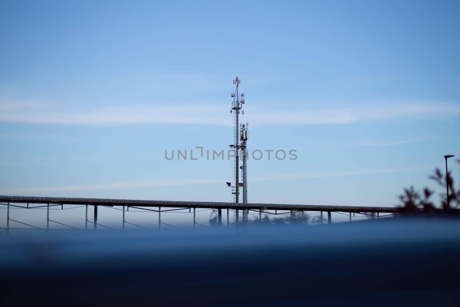 A futuristic cell phone tower rises from the water, its metallic structure gleaming in the sunlight as it provides connectivity to nearby areas.