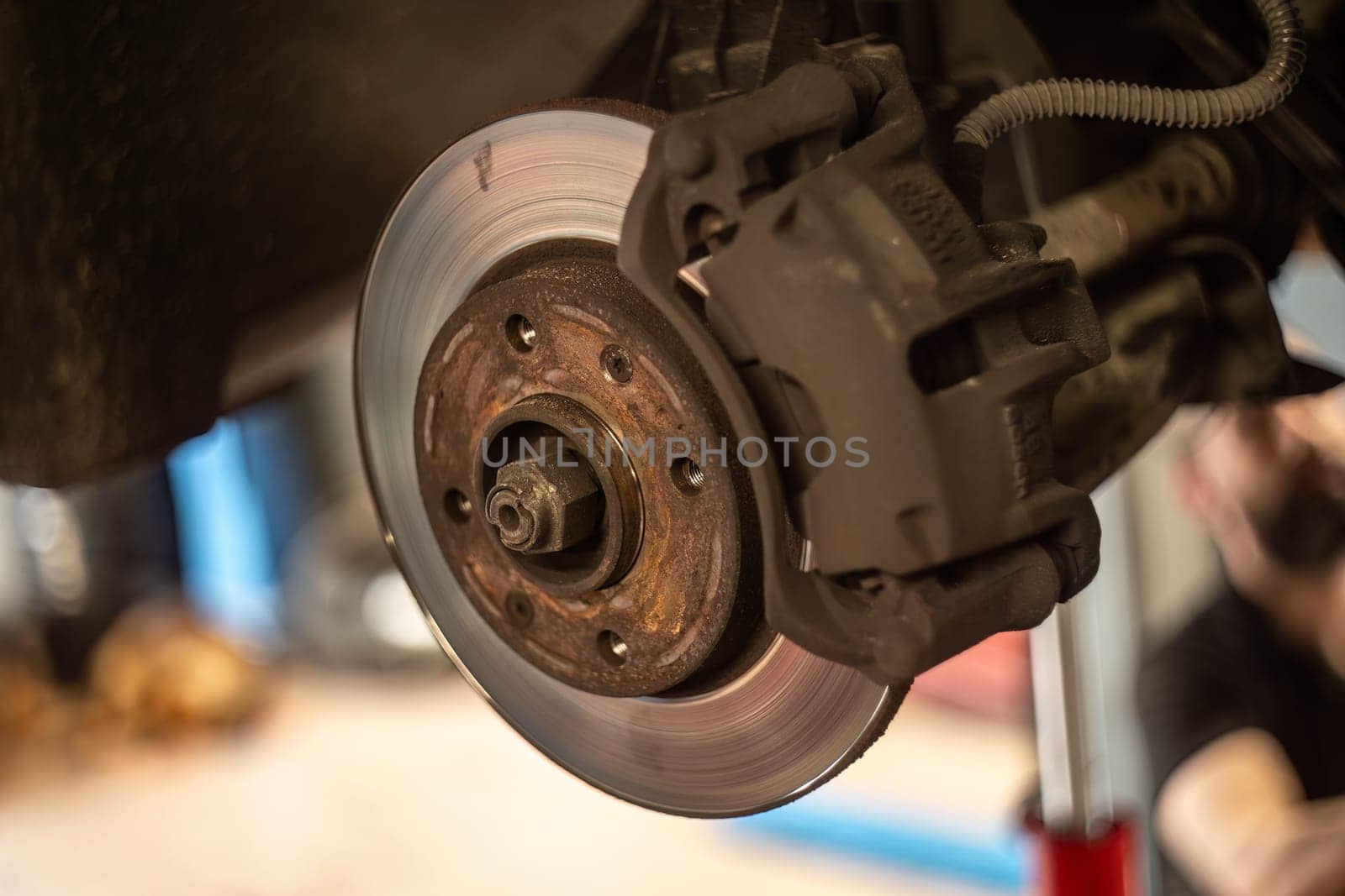 A worn and dirty disc brake undergoing maintenance, crucial for vehicle safety and performance.