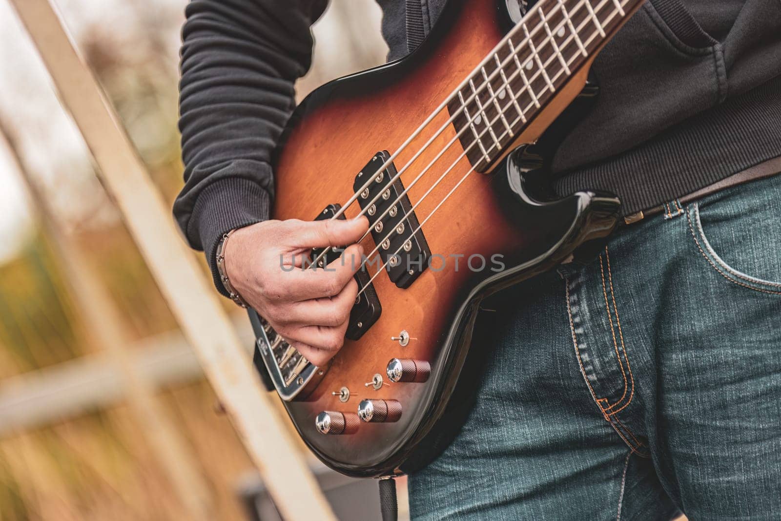 A man holding a bass guitar in his hands, ready to play music.