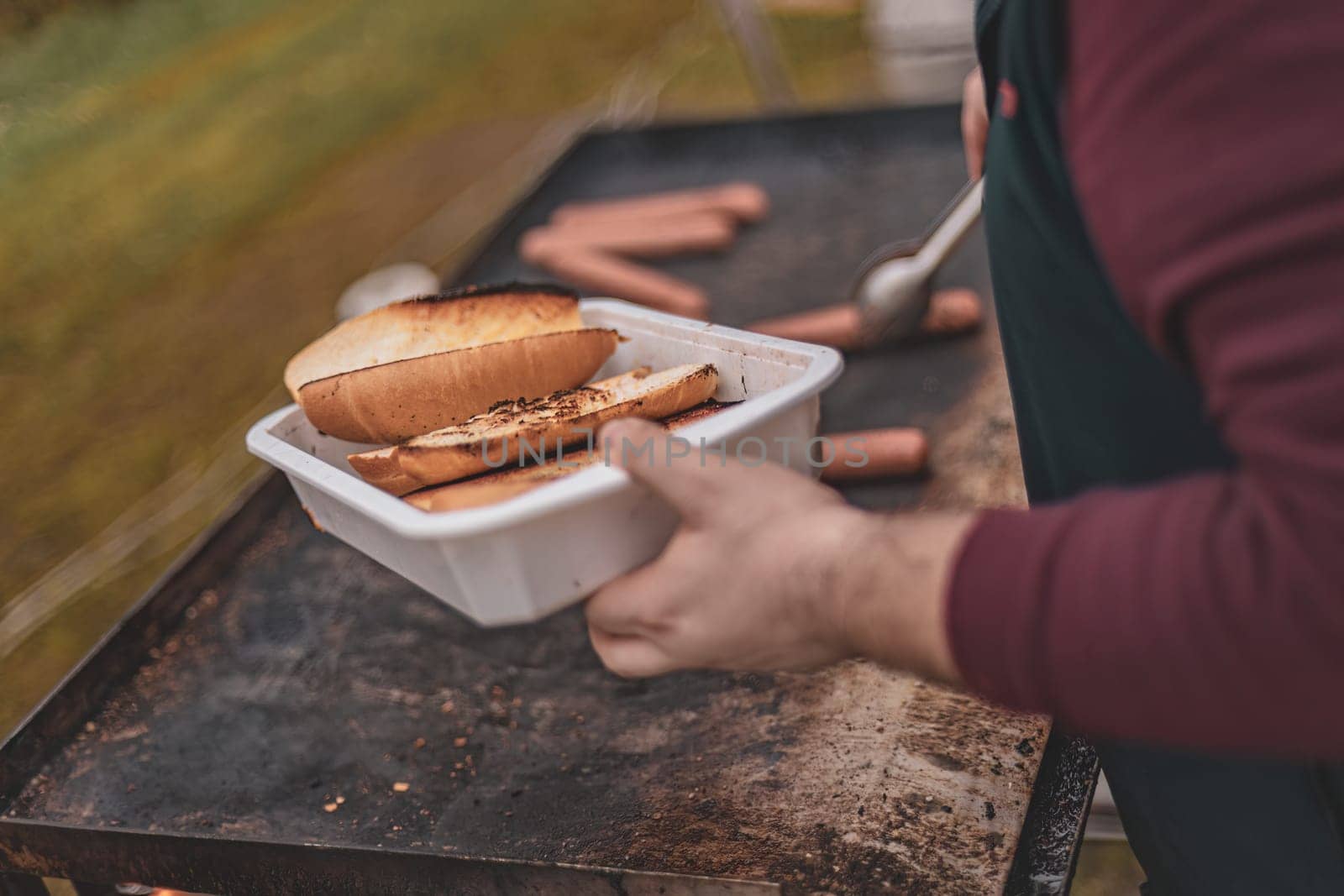 Person Holding Hot Dog in Container by pippocarlot