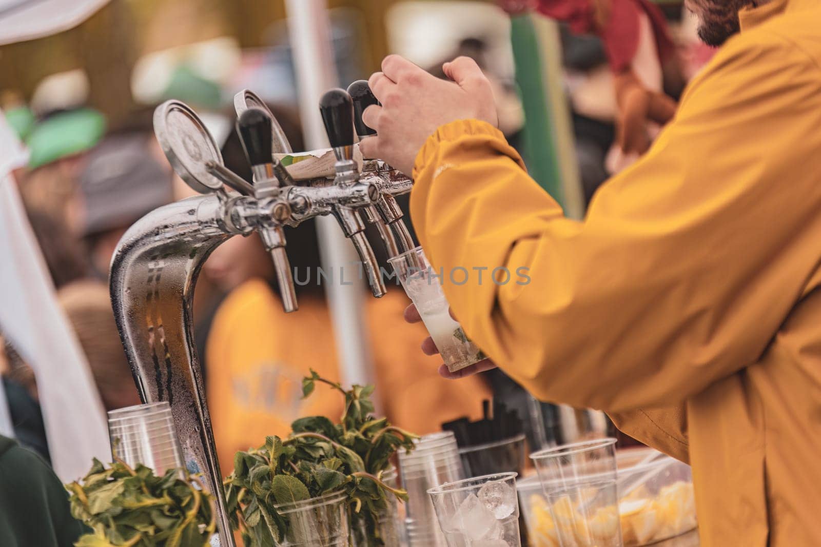 A hand expertly fills a glass with draft beer, capturing the perfect pour and frothy top in action.