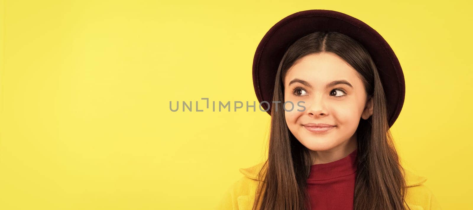 dreamy child with maple leaf on yellow background. autumn. Child face, horizontal poster, teenager girl isolated portrait, banner with copy space