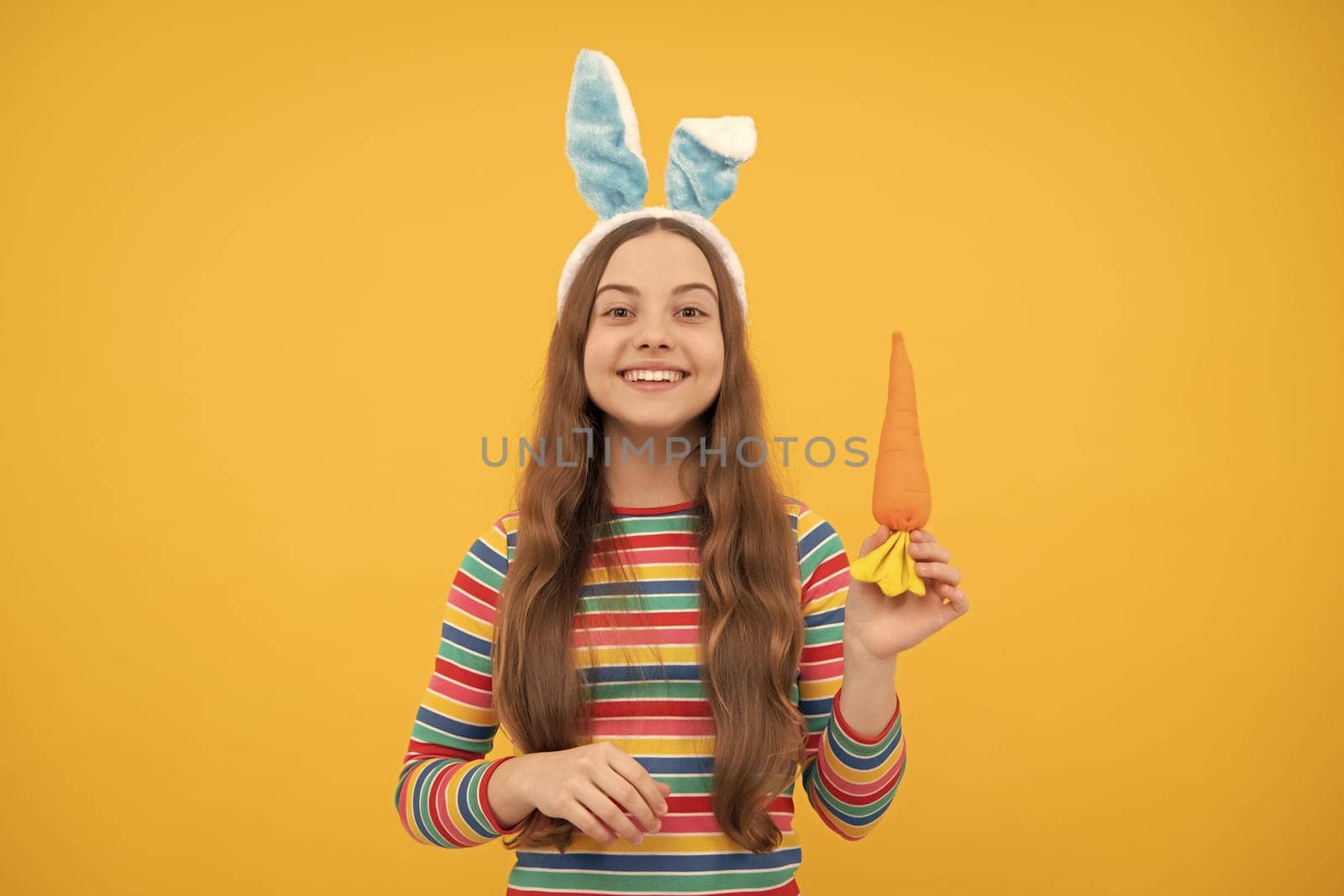 happy easter kid girl in rabbit bunny ears hold carrot for holiday, easter bunny.