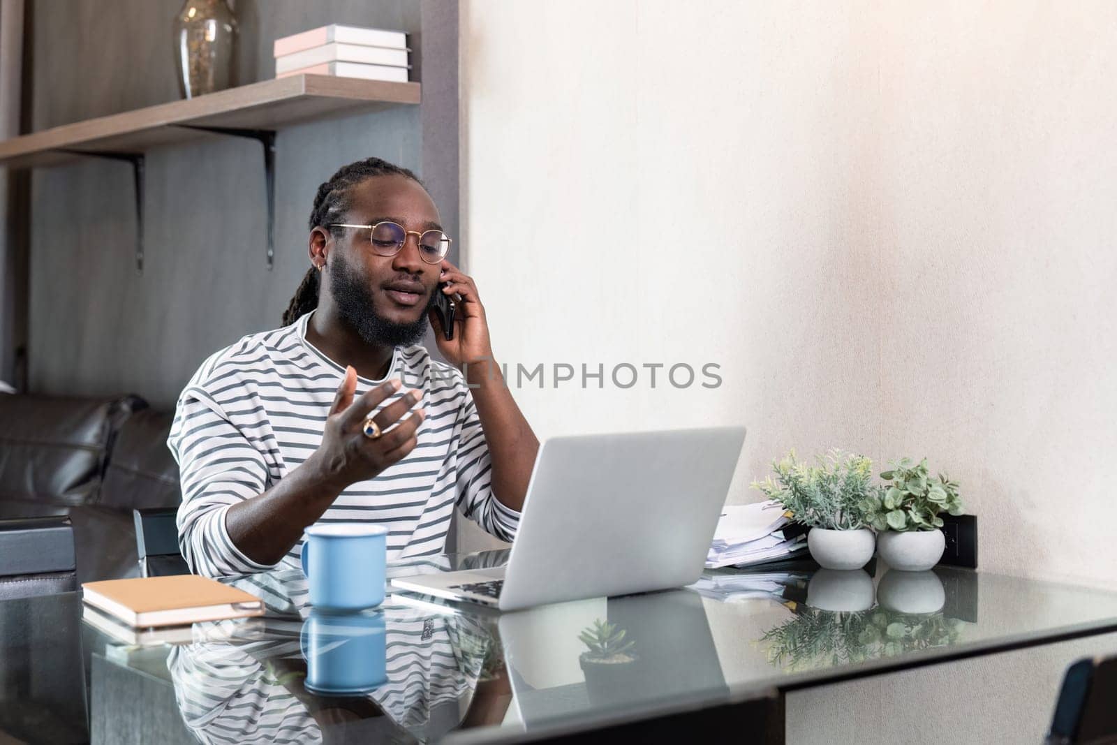 Professional man working remote from home with technology. African American male has a business meeting on an audio call phone.