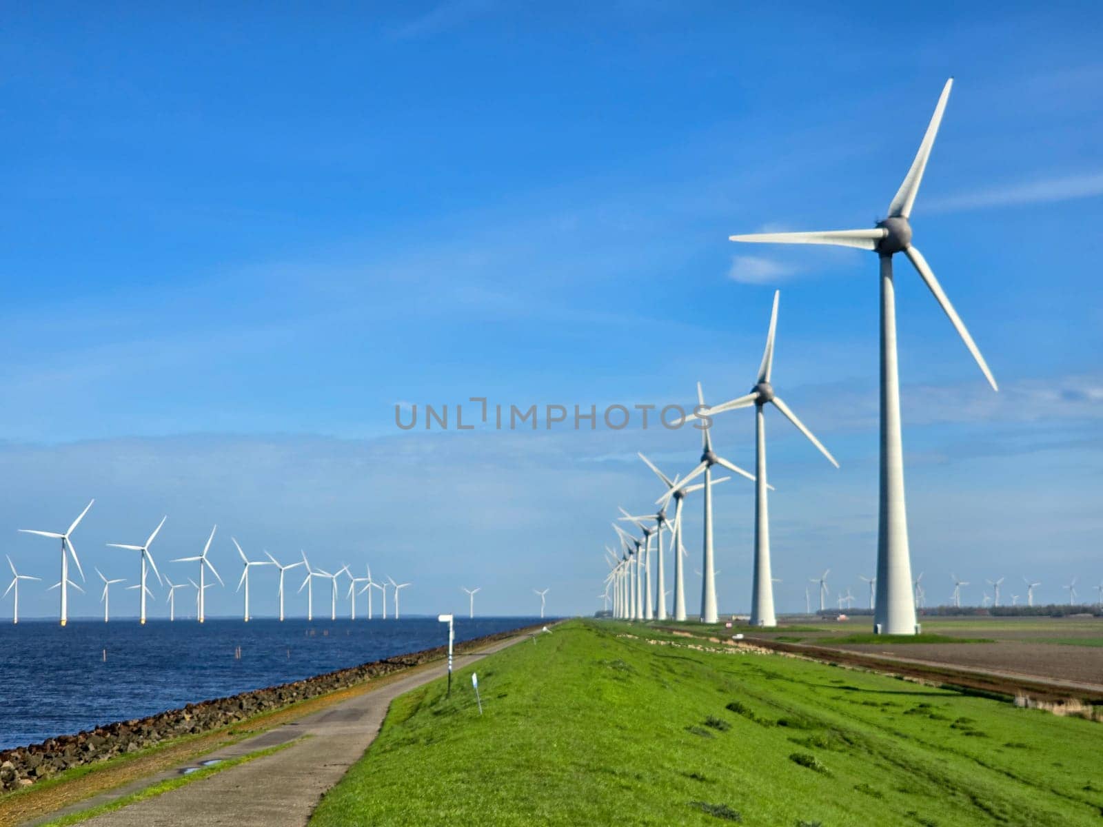 Windmill park in the ocean, drone aerial view of windmill turbines at sea in the Netherlands by fokkebok