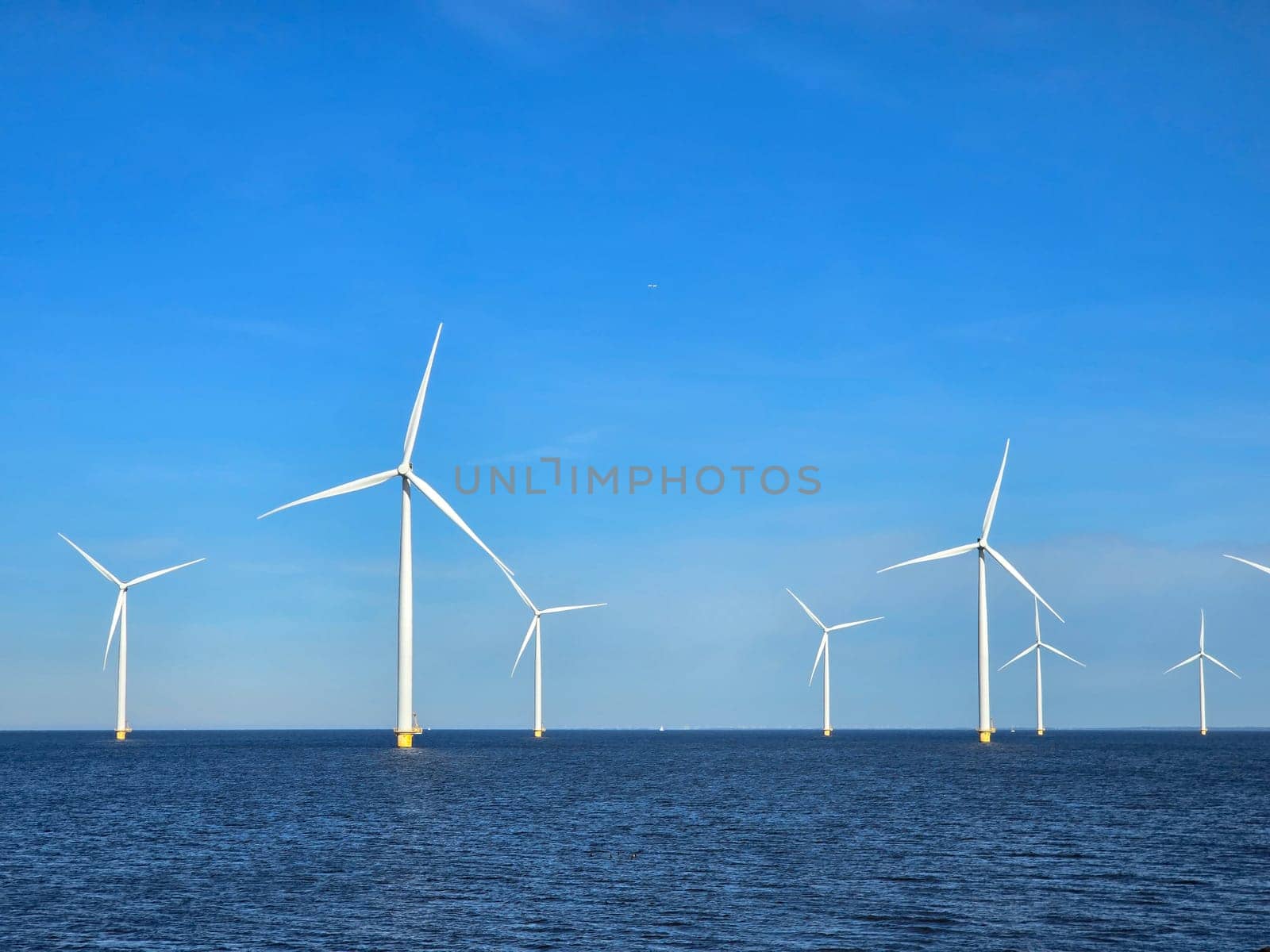 Windmill park in the ocean, drone aerial view of windmill turbines at sea in the Netherlands by fokkebok