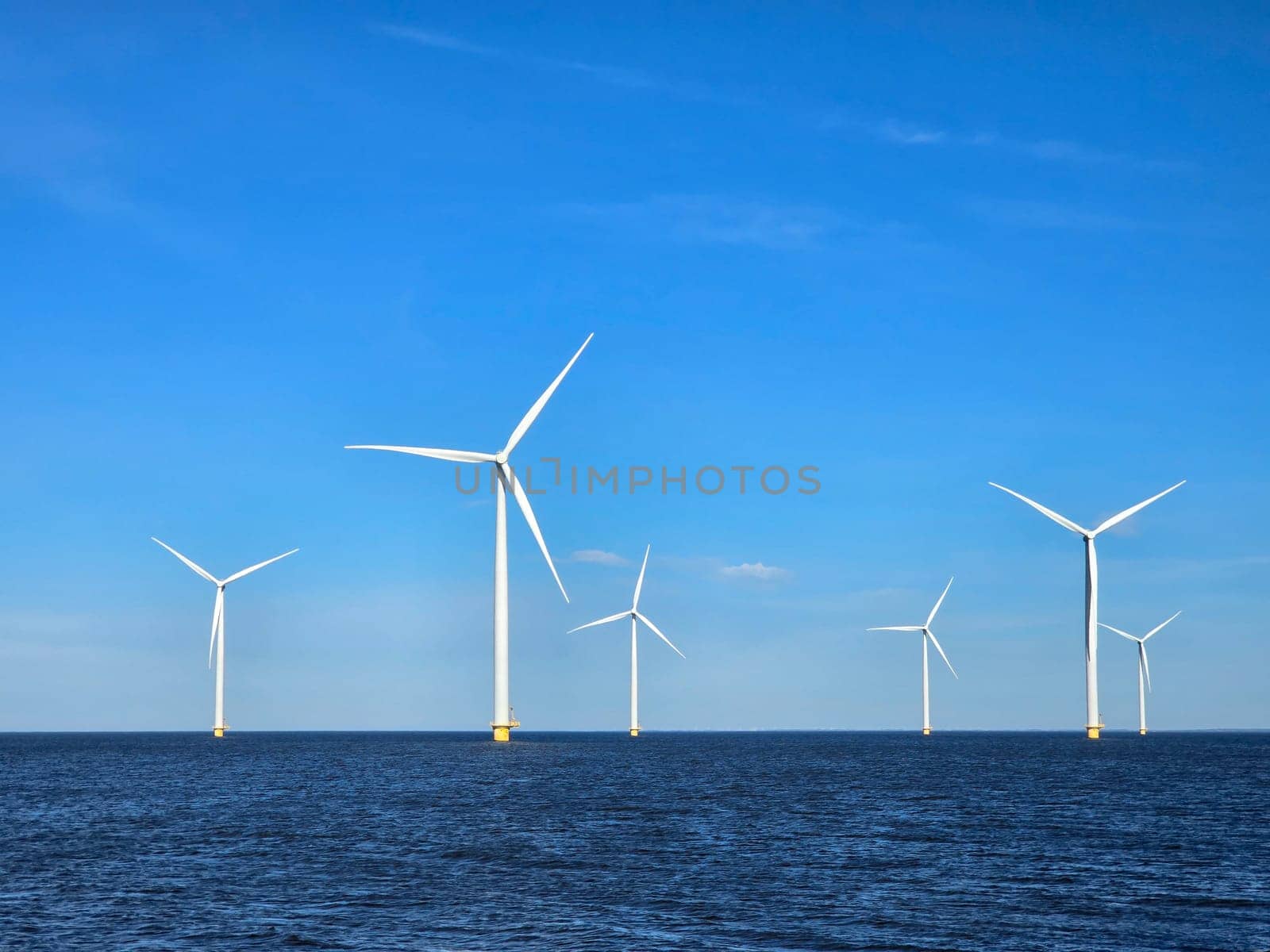 Windmill park in the ocean, drone aerial view of windmill turbines at sea in the Netherlands by fokkebok