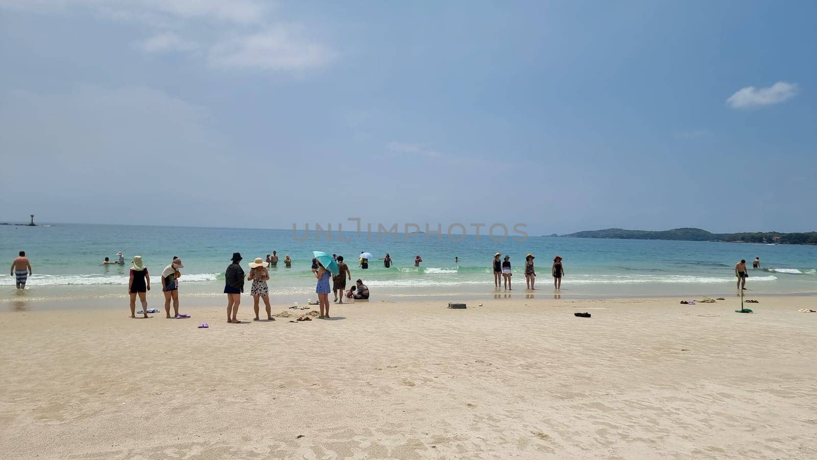 Chinese tourist on the beach of Koh Samet Thailand taking photos and selfies by fokkebok