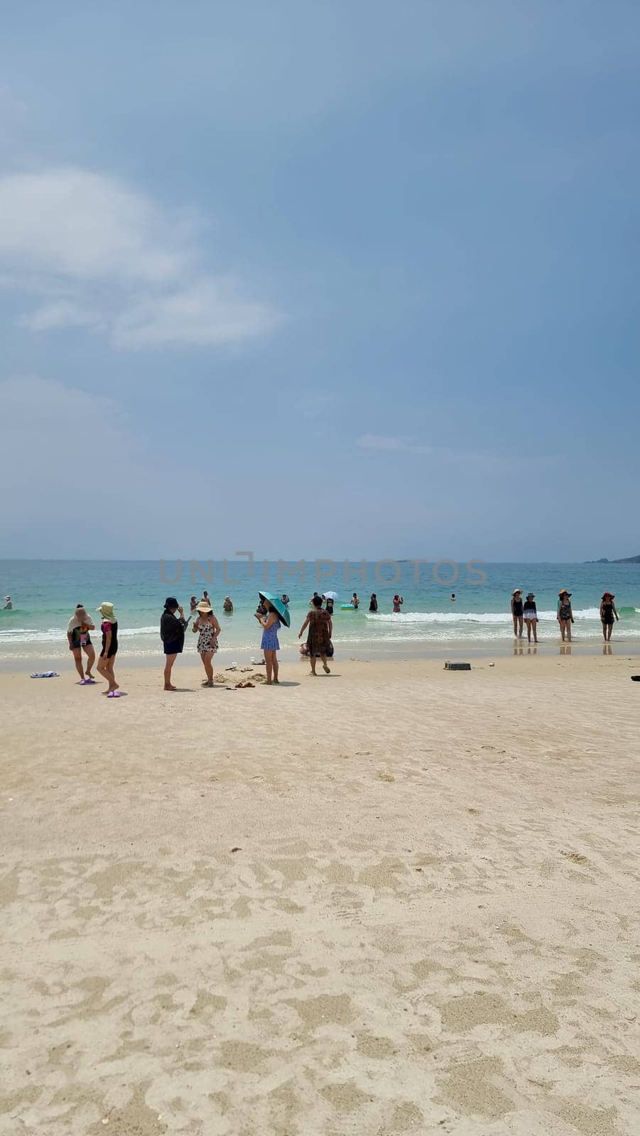Chinese tourist on the beach of Koh Samet Thailand taking photos and selfies by fokkebok