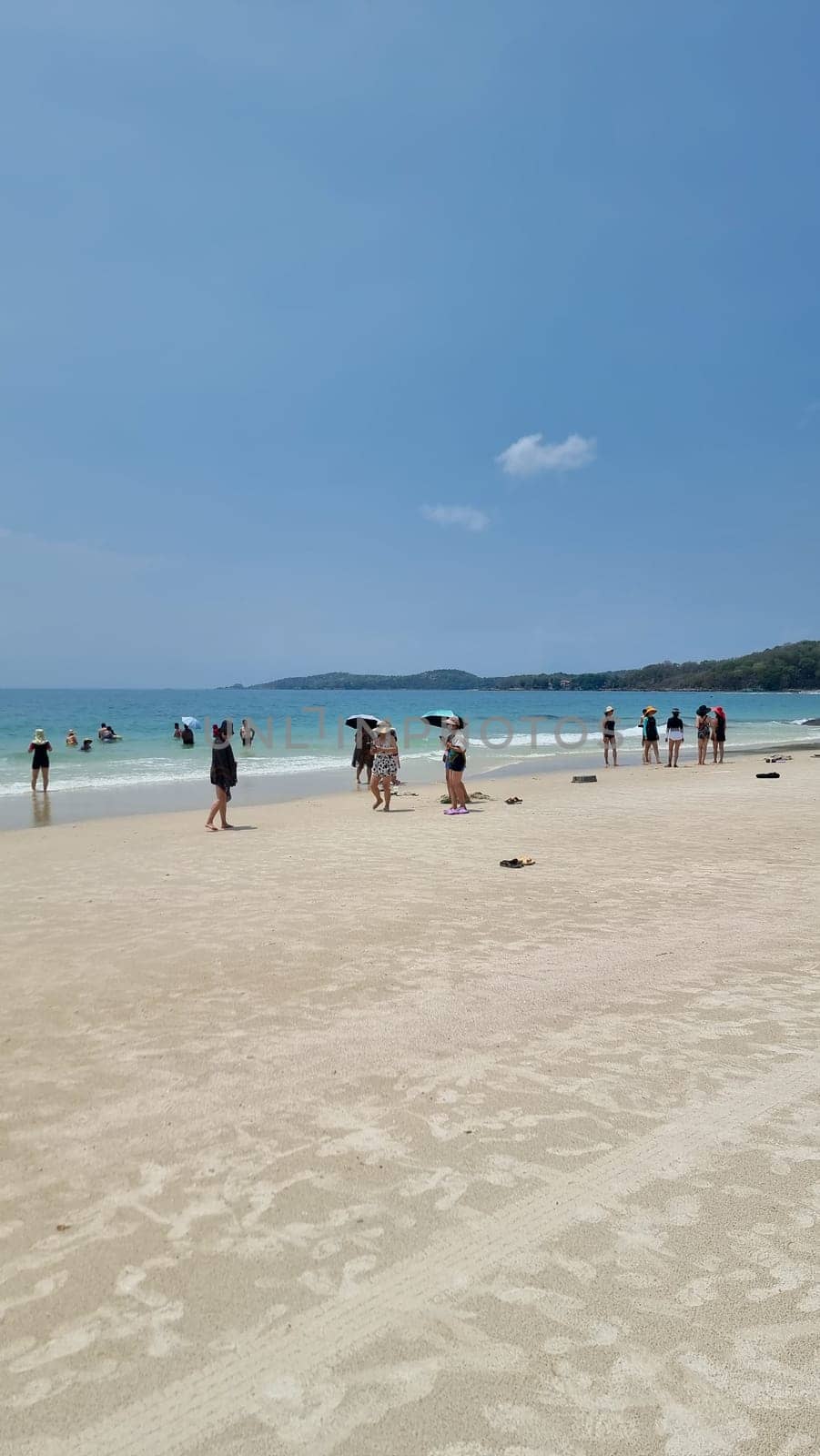 Chinese tourist on the beach of Koh Samet Thailand taking photos and selfies by fokkebok