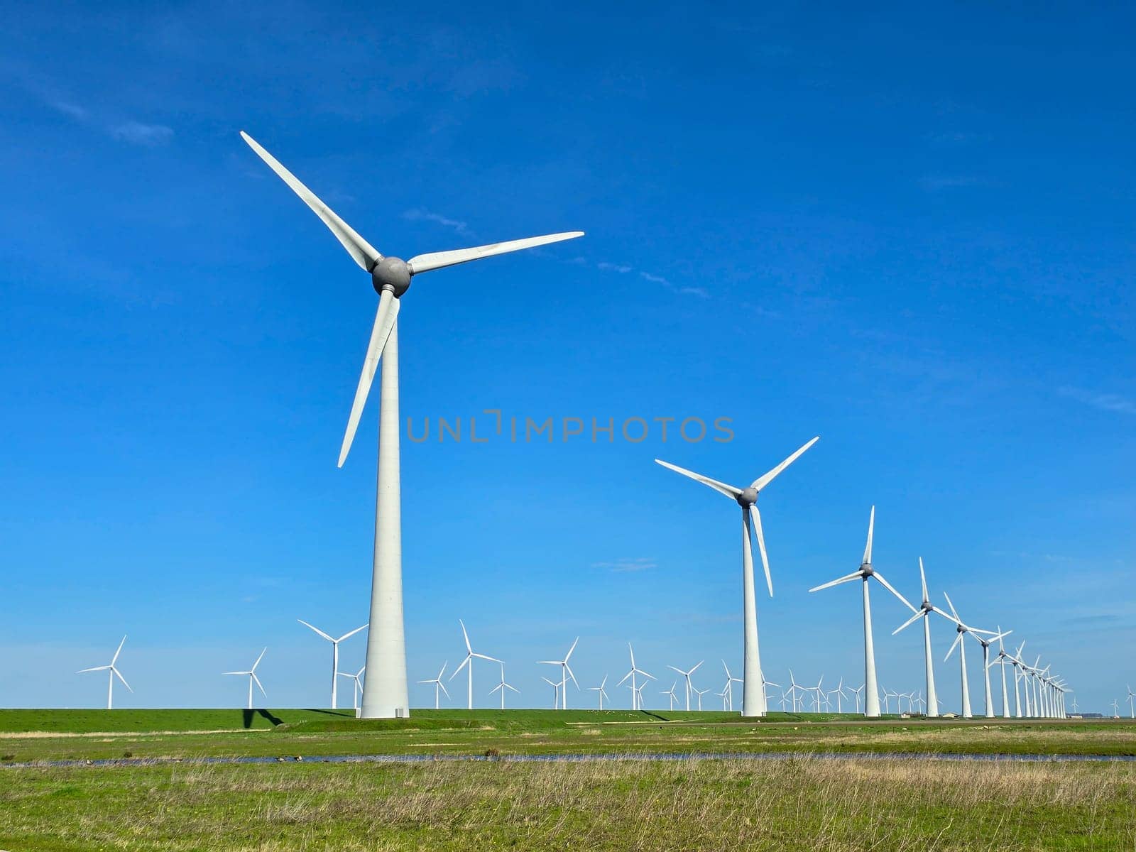 Windmill park in the ocean, drone aerial view of windmill turbines at sea in the Netherlands by fokkebok