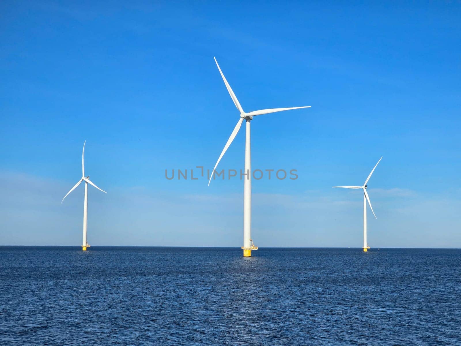 Windmill park in the ocean, drone aerial view of windmill turbines at sea in the Netherlands by fokkebok