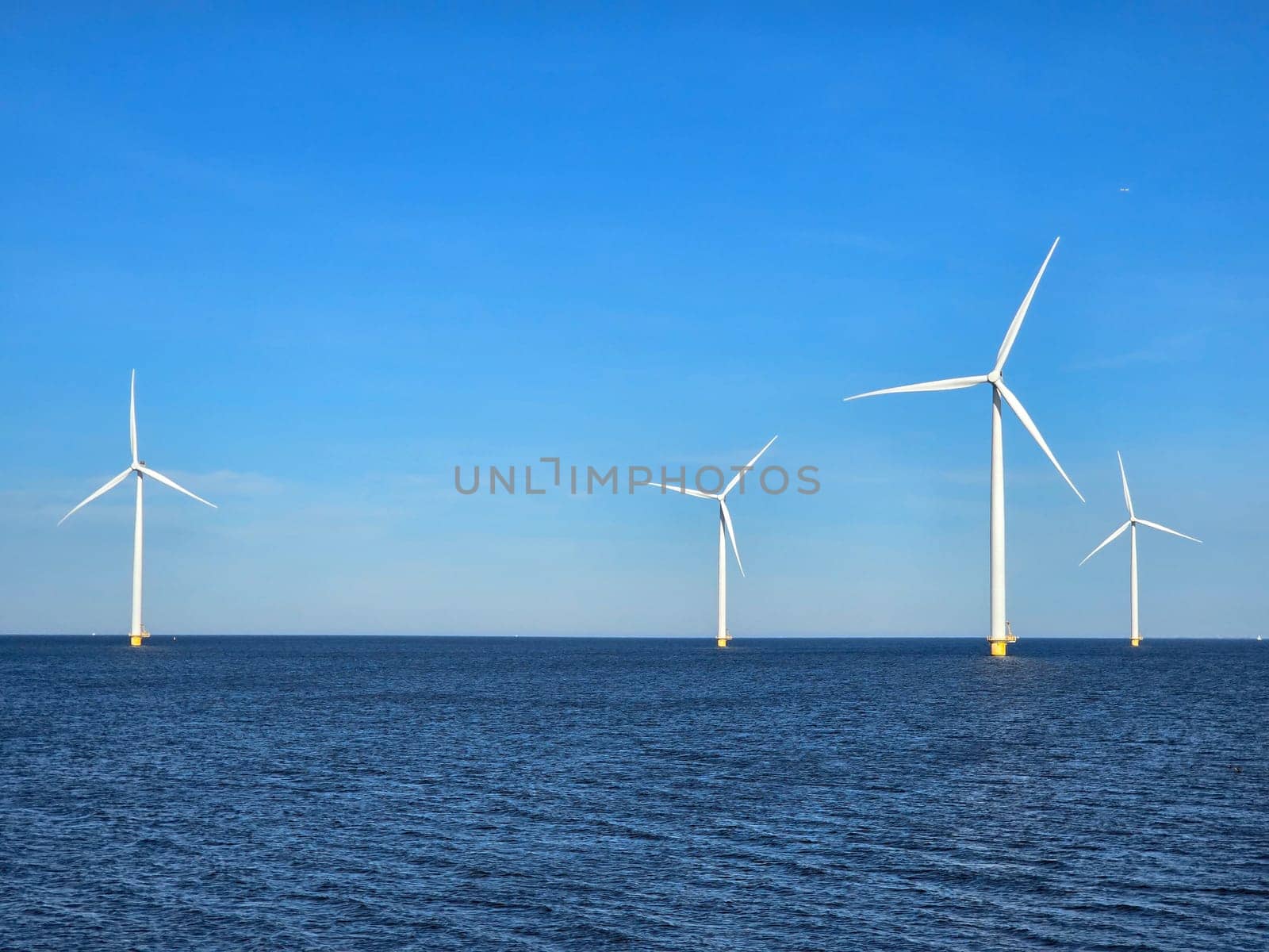 Windmill park in the ocean, drone aerial view of windmill turbines at sea in the Netherlands by fokkebok