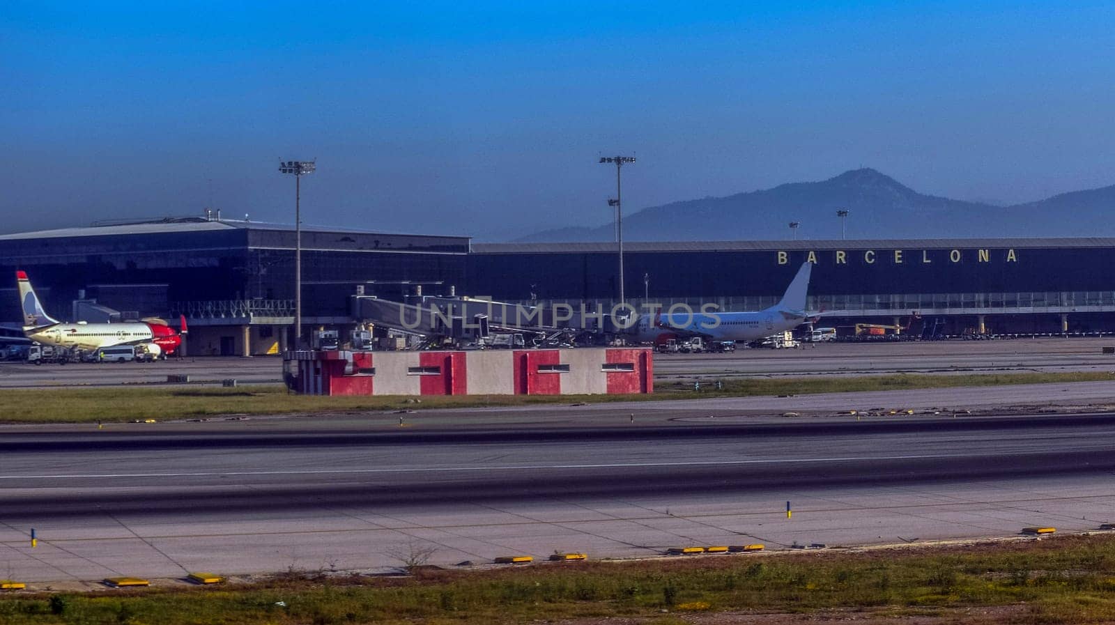 Barcelona airport with parked planes and mountains in the background with mountain view. High quality photo