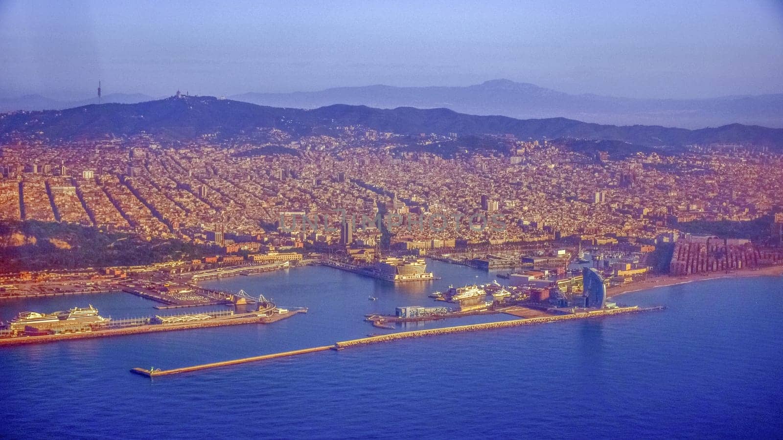 flying over Barcelona city view from the sea, seaport, skyscraper on the beach and Barceloneta