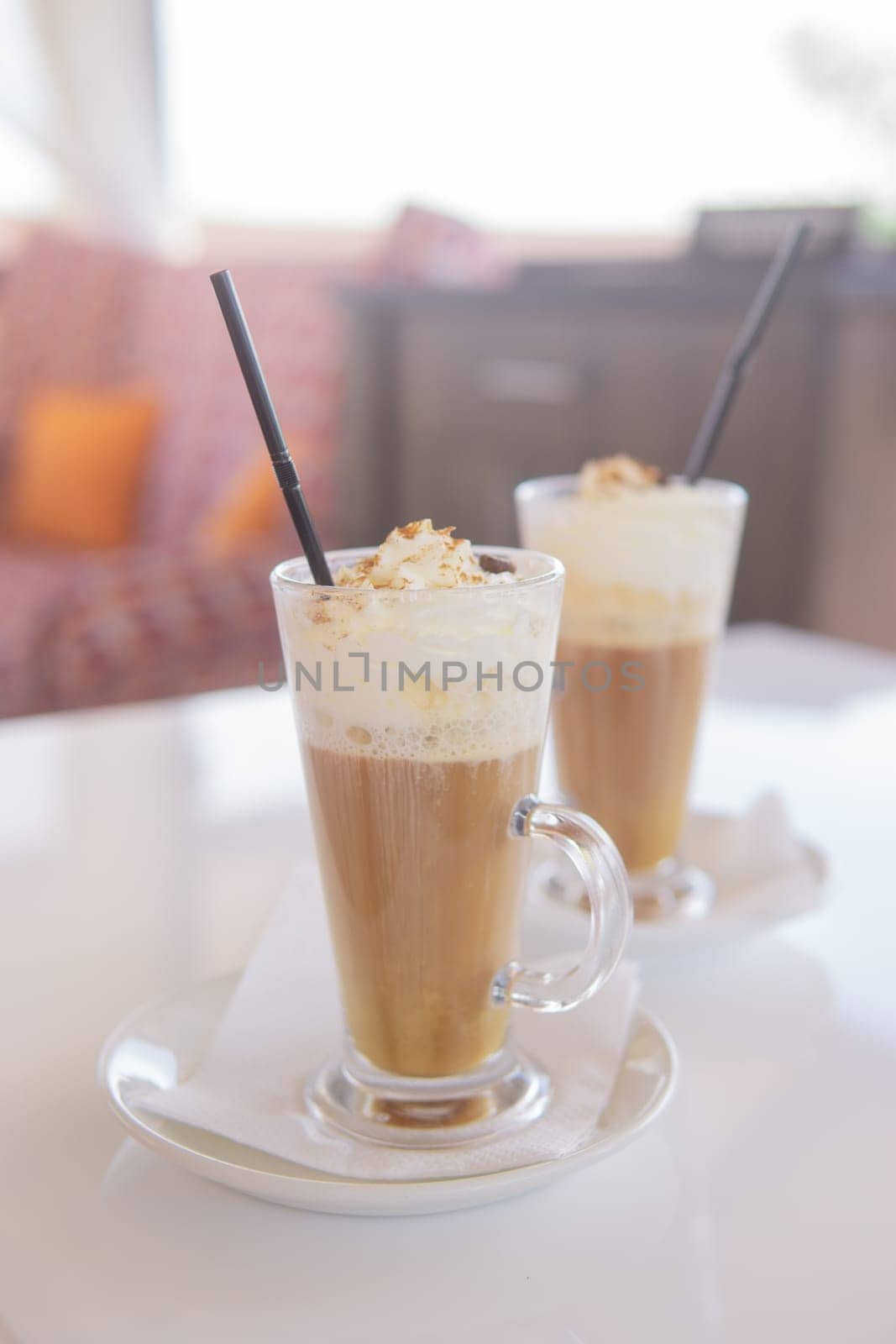 coffee is served in a tall glass glass with a straw. The concept of coffee drinks from the bar menu.