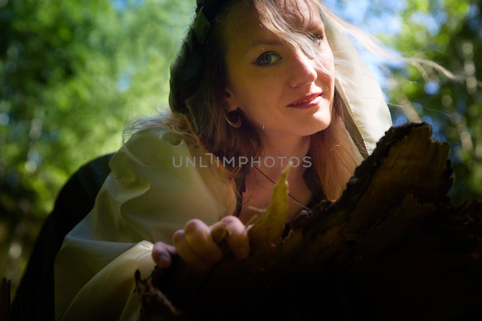 Beautiful seductive dryad. Pagan spirit of forest. Portrait of beautiful dryad. Fairy who loves nature in beautiful green summer forest. Concept of environmental friendliness and caring for nature
