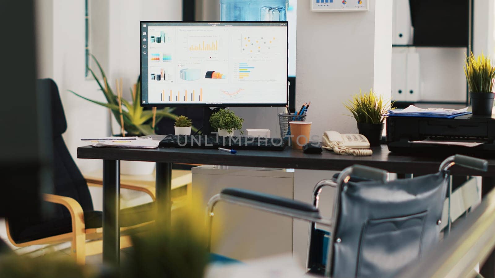 Company workspace with nobody in and marketing pie charts on computer monitors by DCStudio