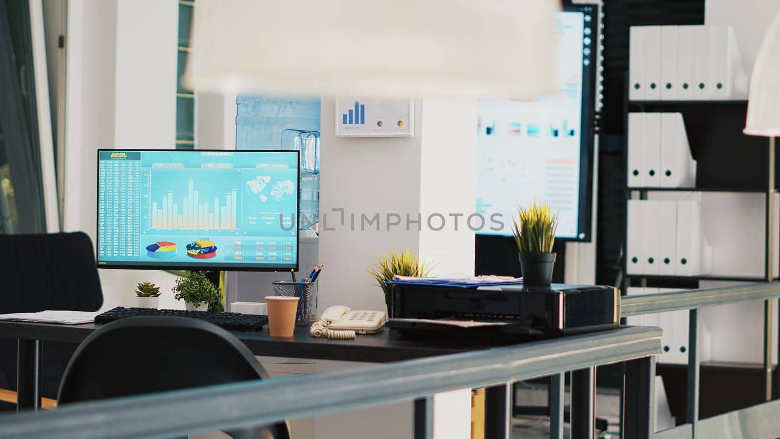 Office with stock exchange listings and business charts displayed in background by DCStudio