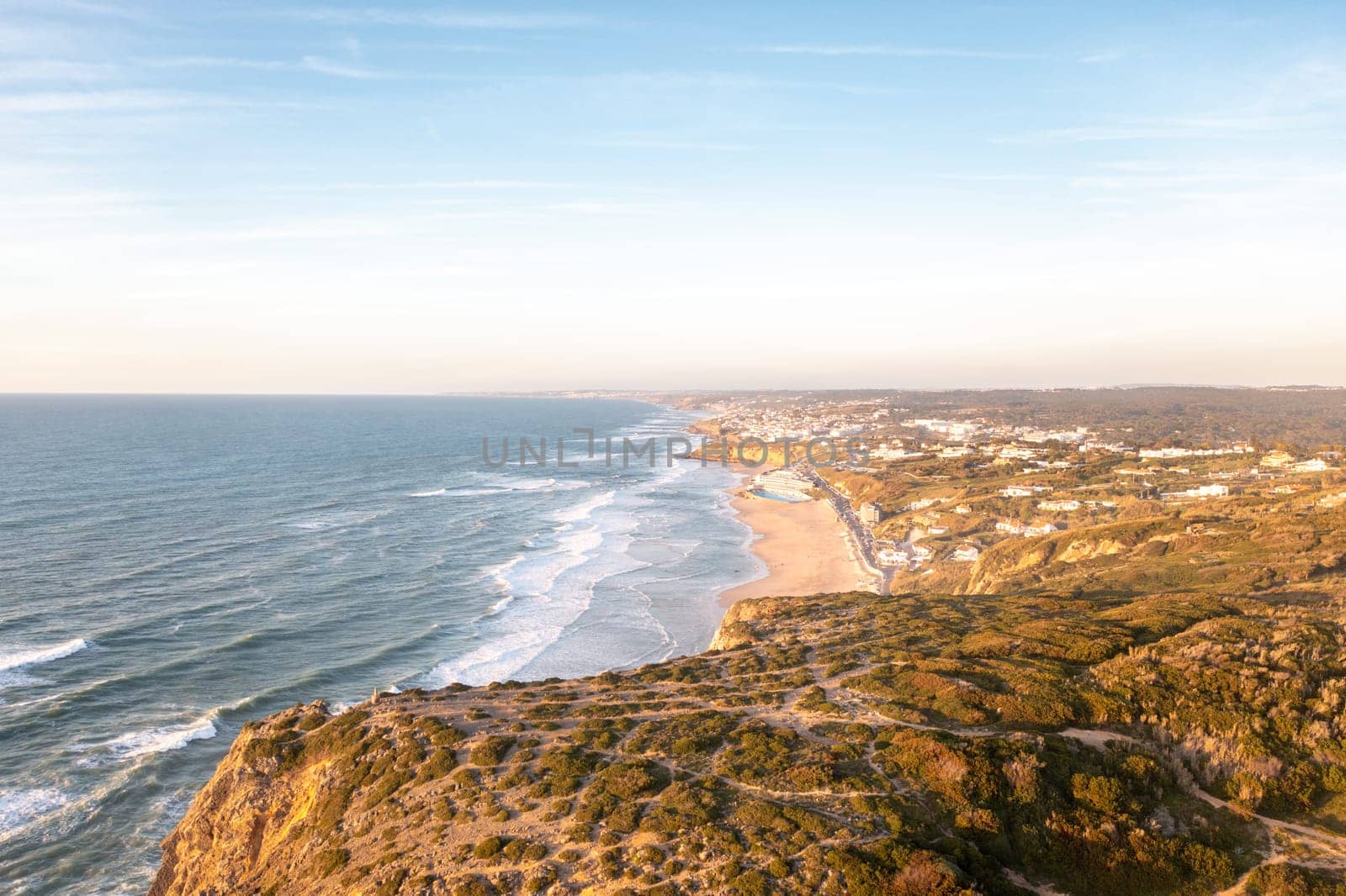 Sunset on the beach Praia Grande, Portugal. Beautiful sunset on the Portuguese beach Praia Grande, in Portugal. Beach of Praia Grande. View of Atlantic beach and big waves. Colares, Sintra, Portugal.