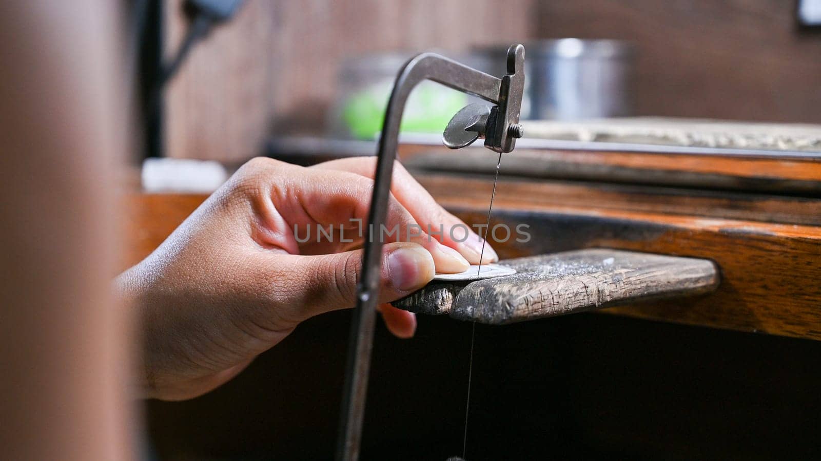 Craftsman creating ornate jewelry at workbench by Peruphotoart