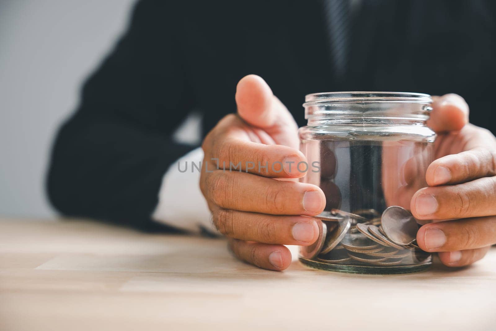 Hands of adults holding money jar with house icon by Sorapop